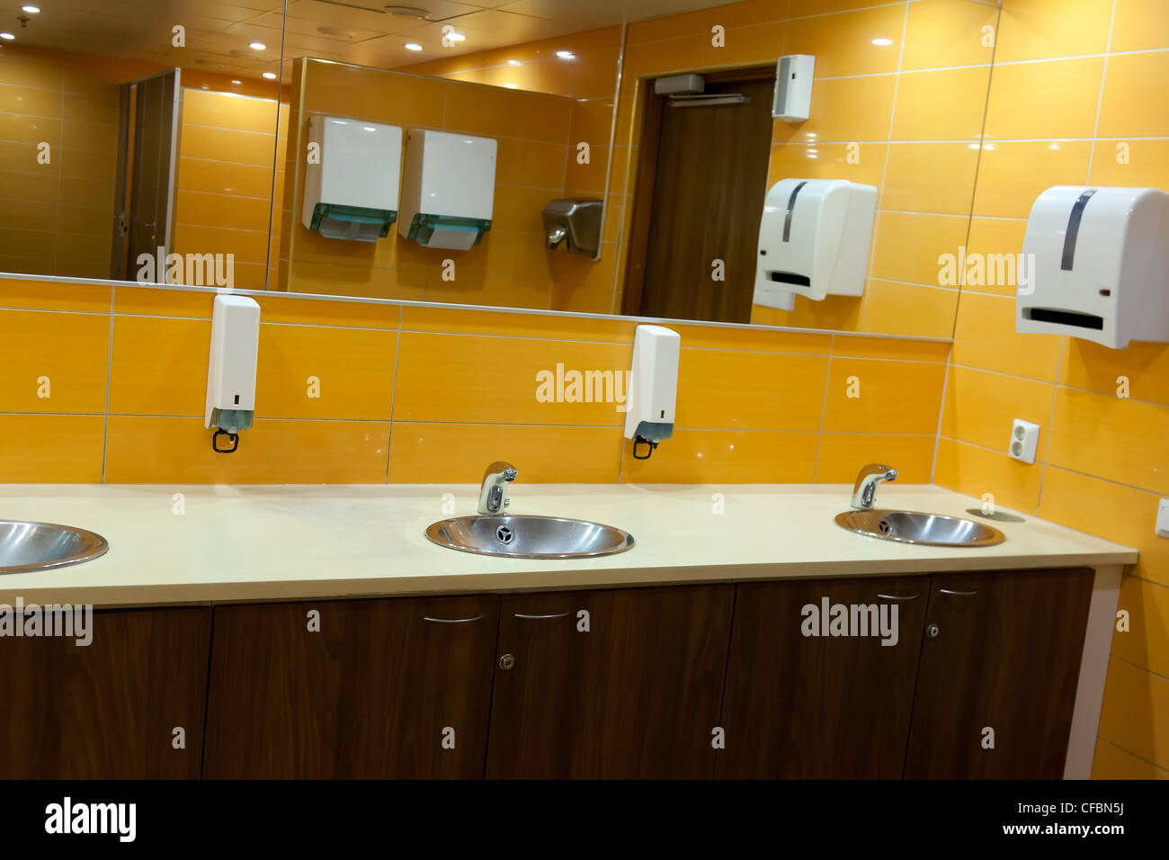 Waschbecken Sie in einer öffentlichen Toilette mit gelben Wänden Stockfoto