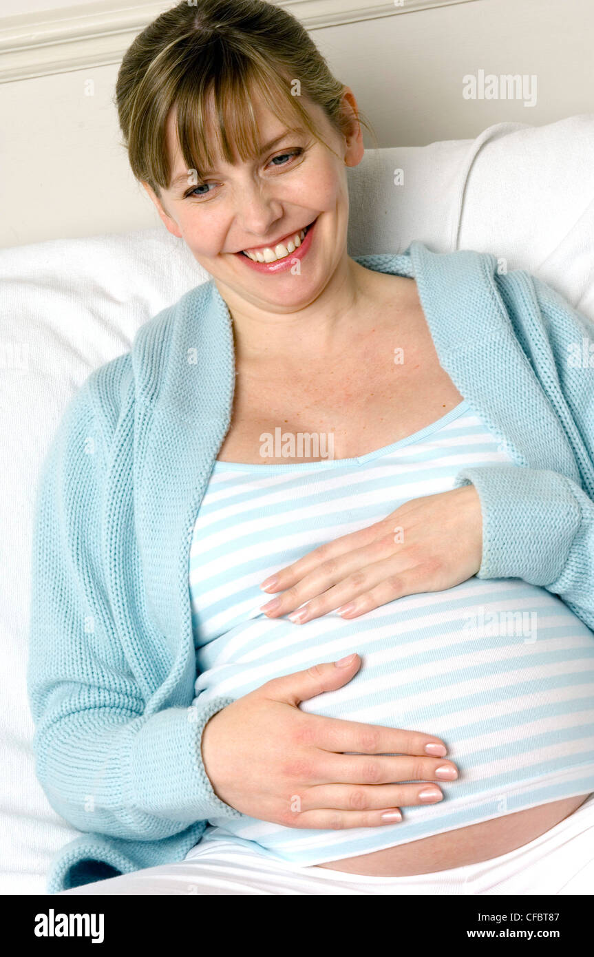 Trächtige Weibchen mit den Händen auf Stoß Stockfoto