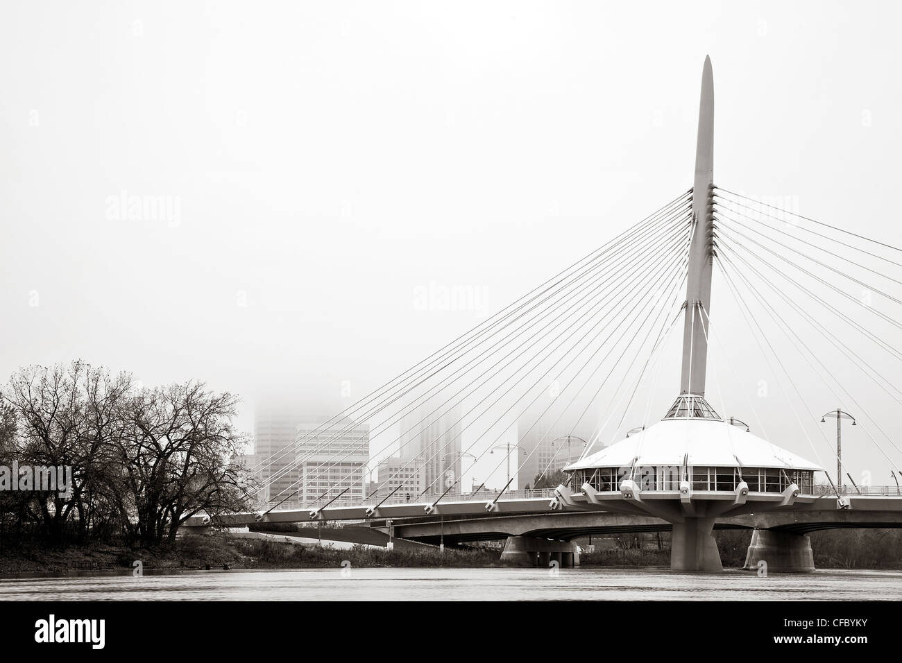 Esplanade Riel Brücke über den Red River an einem nebligen Herbst-Morgen. Skyline von Winnipeg, Manitoba, Kanada im Hintergrund. Stockfoto