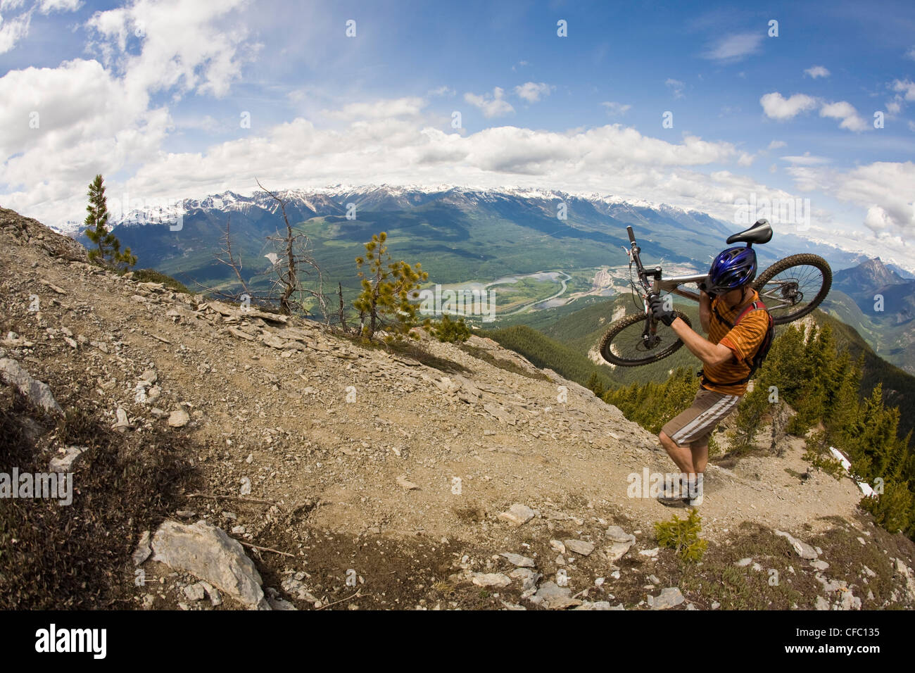 Mann mittleren Alter trägt seinem Mountainbike bis Mt. sieben für eine epische Abstieg. Golden, BC Stockfoto