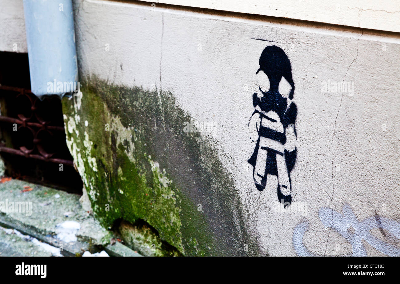 Schablone Graffiti von einem Mädchen mit einer Gasmaske nächste Schimmel wächst aus einem Abflussrohr in Vilnius, Litauen Stockfoto