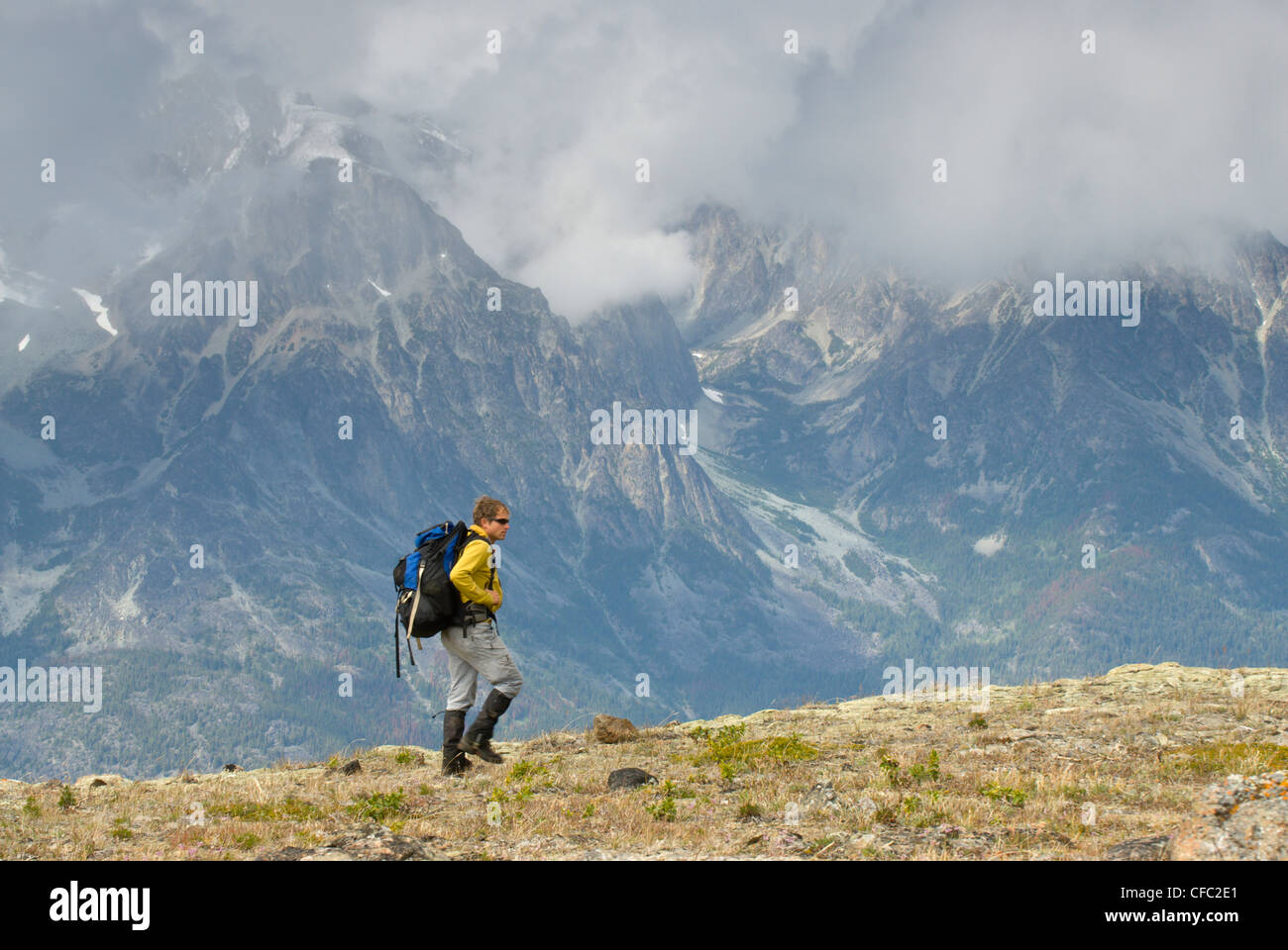 Ein Wanderer durchquert einen Grat im Bereich Kartoffel mit einem nebligen Blick des Bereichs Niut hinter, British Columbia, Kanada Stockfoto
