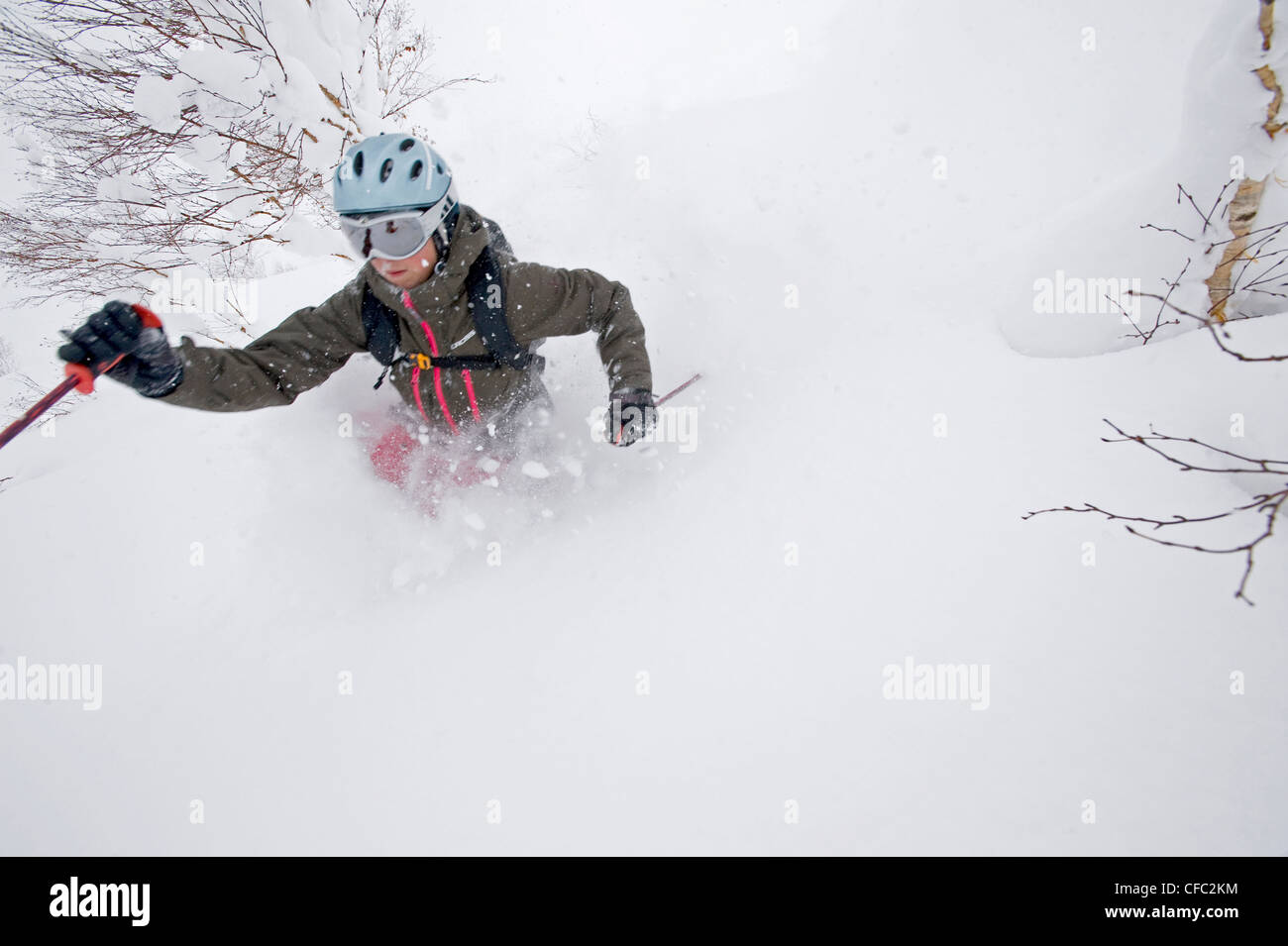 Eine Skifahrerin im Tiefschnee in Niseko Ski Gebiet, Hokkaido, Japan Stockfoto