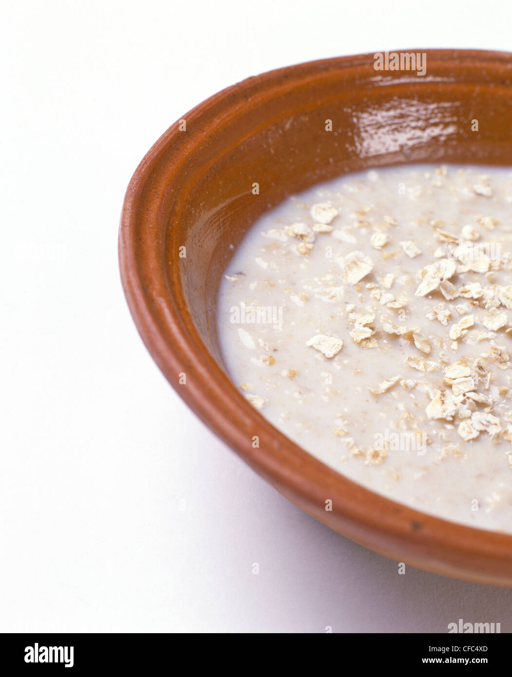 Brei Haferflocken mit Milch in Schüssel Terrakotta Stockfoto