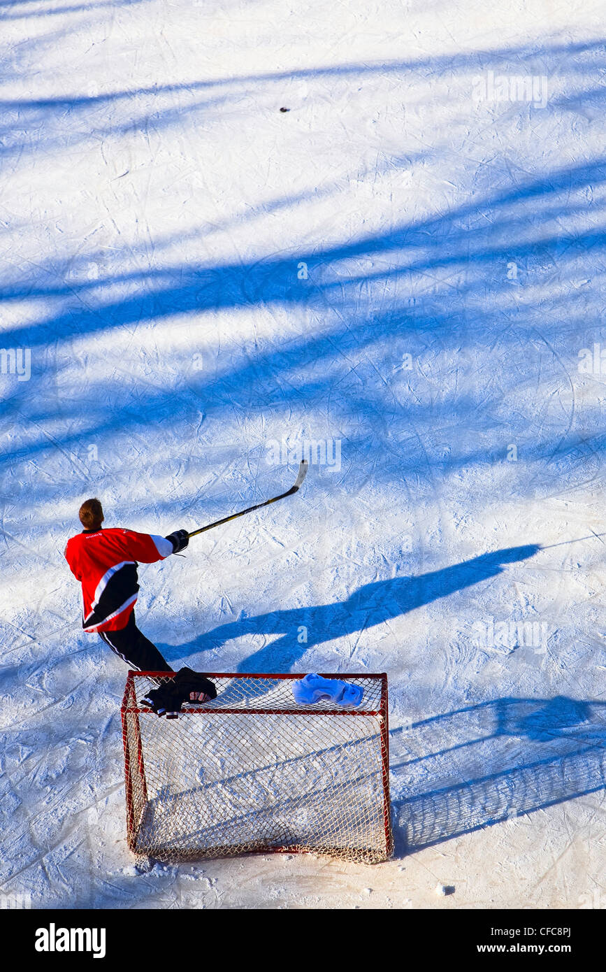 Teenager spielen Eishockey auf dem zugefrorenen Assiniboine River. Die Gabeln, Winnipeg, Manitoba, Kanada. Stockfoto