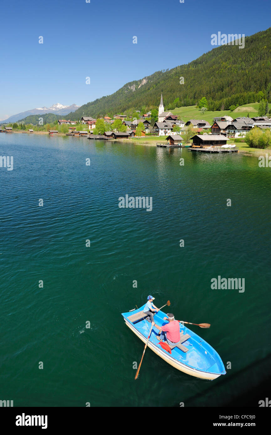 Zwei Personen ein Ruderboot am Weissensee, Dorf Gatschach im Hintergrund, den Weissensee, Kärnten, Österreich, Europa Stockfoto