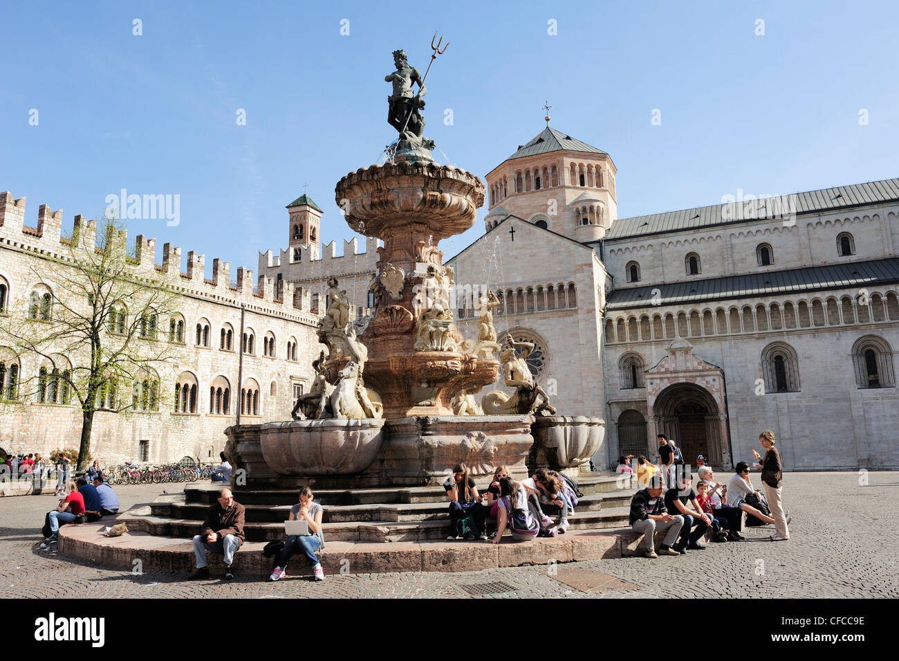 Gruppe von Menschen sitzen an einem Brunnen am Stadtplatz, Kathedrale im Hintergrund, Trento, Trentino, Italien, Europa Stockfoto