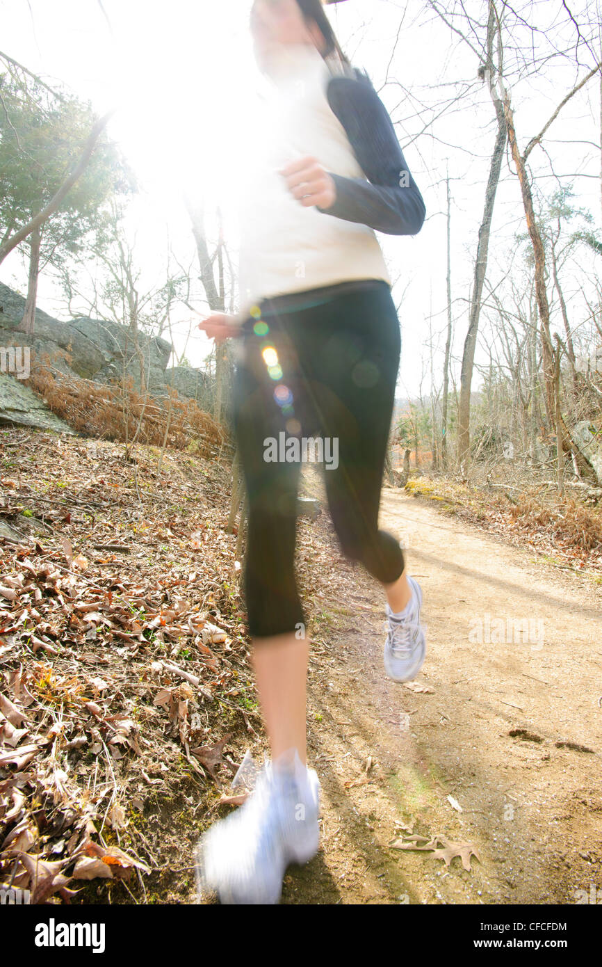 Athletische Frauen laufen auf einem Pfad in den Wald im Winter. Stockfoto