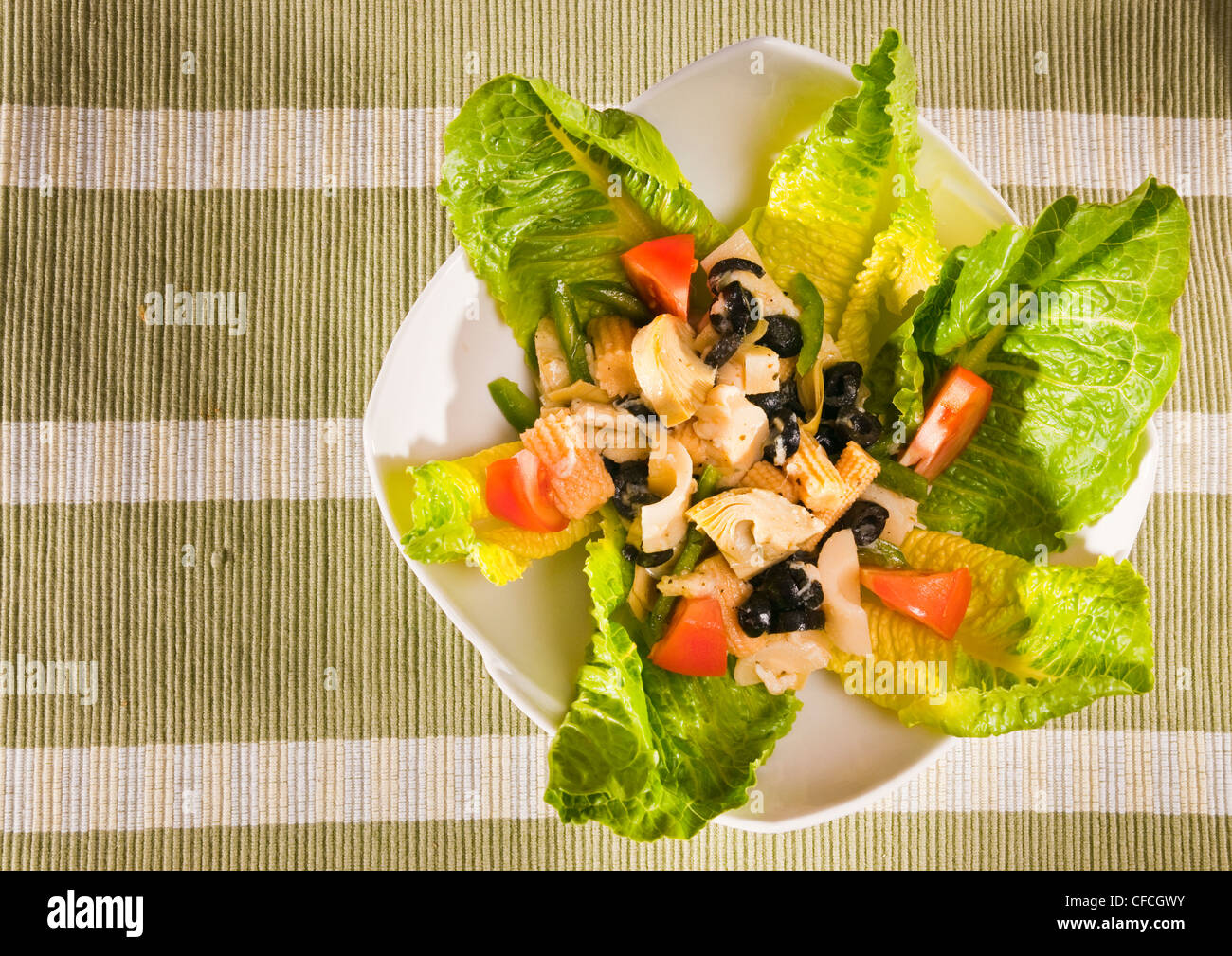 Antipasti-Salat mit Kopfsalat, Tomaten, Oliven und Mais Stockfoto