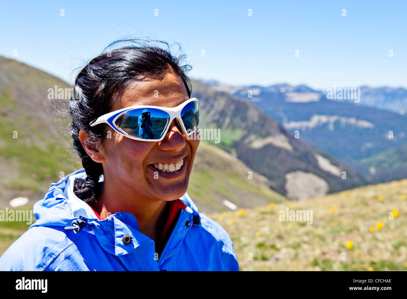 eine Frau lächelt und Ausblicke auf die Rocky Mountains sind hinter ihr. Sie ist auf dem Continental Divide Trail (CCT, Trail-Nummer 813 Stockfoto