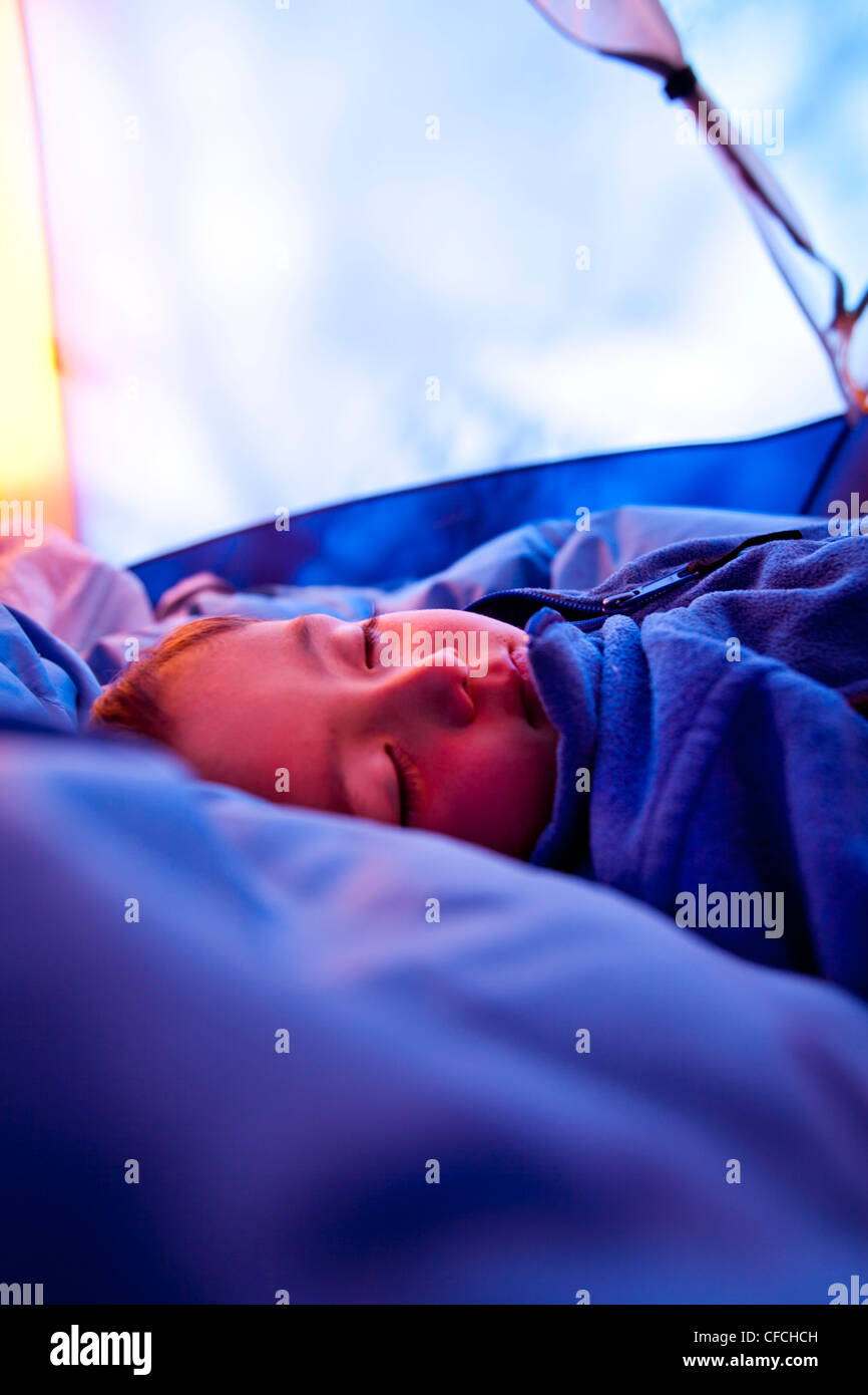 ein Junge schläft auf einem Schlafsack in einem Zelt auf ihrem Campingplatz am Squaw Pass. Stockfoto
