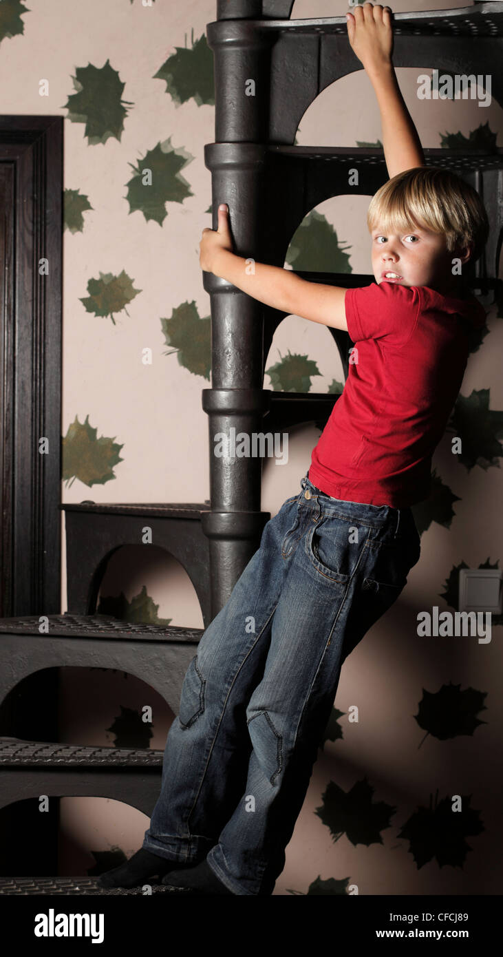 Junge in rot auf Treppen, innen zu spielen hängen Stockfoto