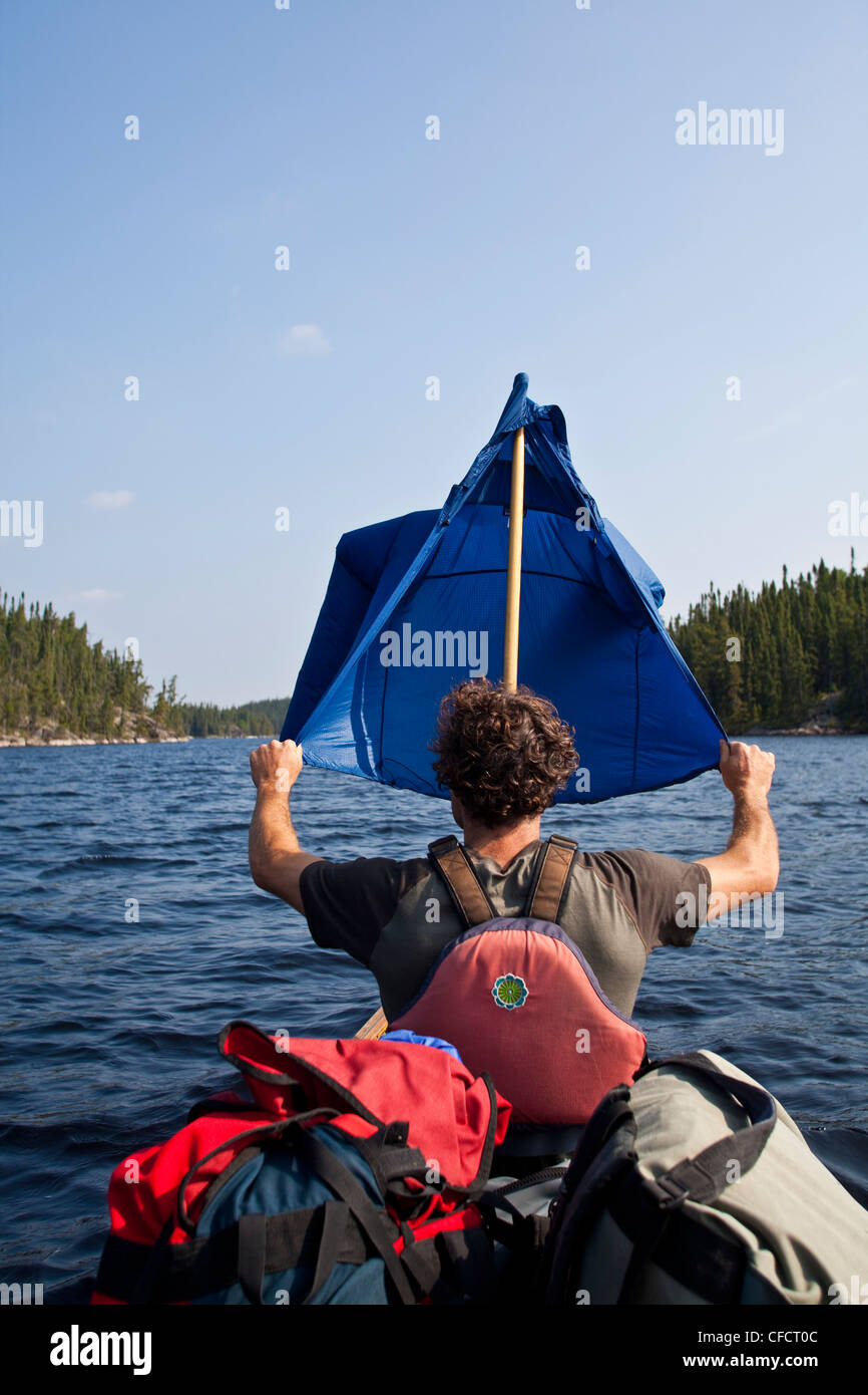 Ein Mann versucht, Segeln bei einer Kanutour in Wabakimi Provincial Park, Ontario, Kanada Stockfoto