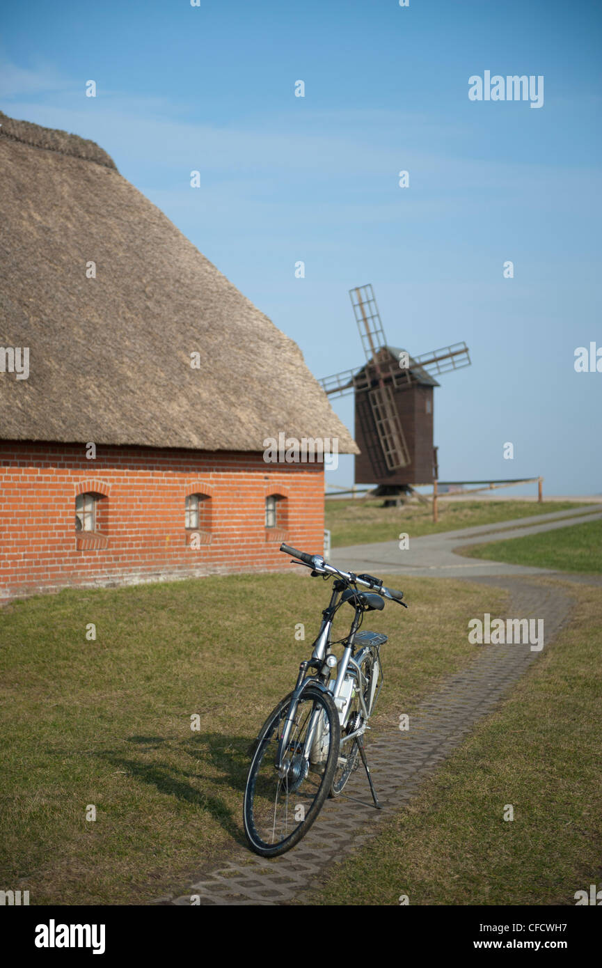 Windmühle und traditionellen Bauernhaus am Ketelswarf auf Hallig Langeness, ein Meer Watteninsel am besten mit dem Fahrrad erkundet Stockfoto