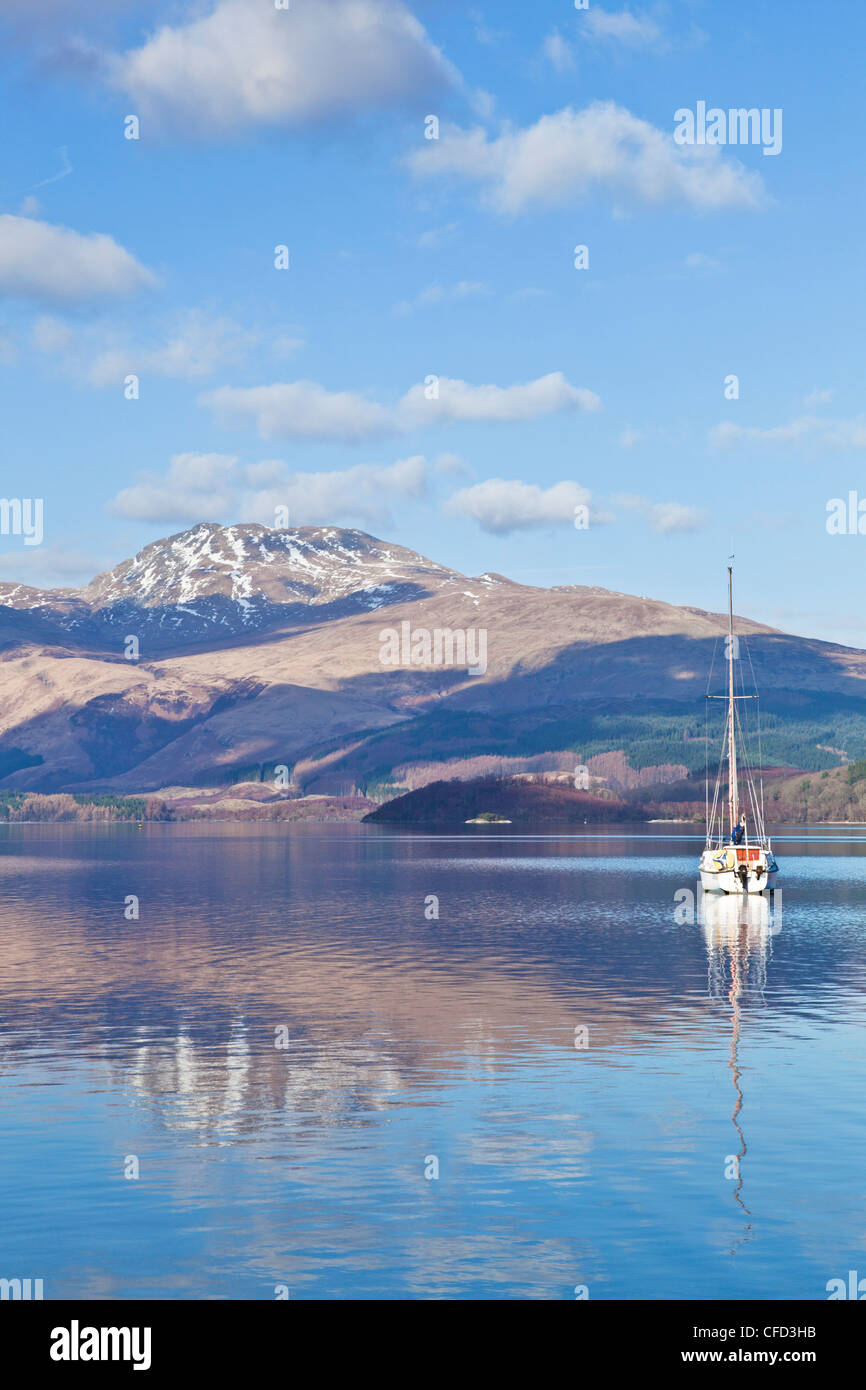 Loch Lomond mit Segelboot, Schnee bedeckt Beinn Uird hinter, von Luss Jetty, Luss, Argyll and Bute, Scotland, UK Stockfoto