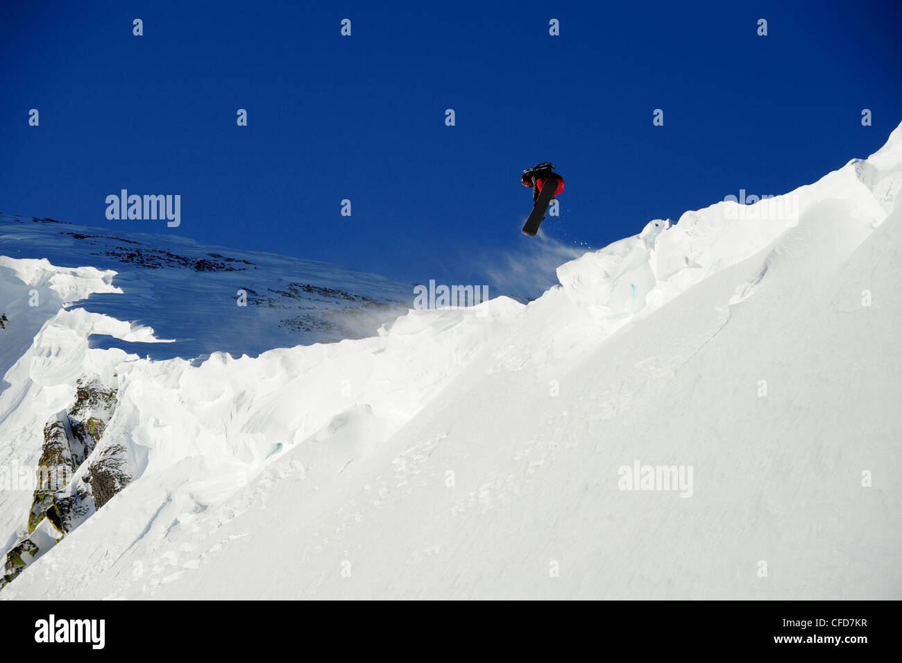 Ein Snowboarder zieht Luft aus einem Gesims im Lake Tahoe Hinterland, California. Stockfoto