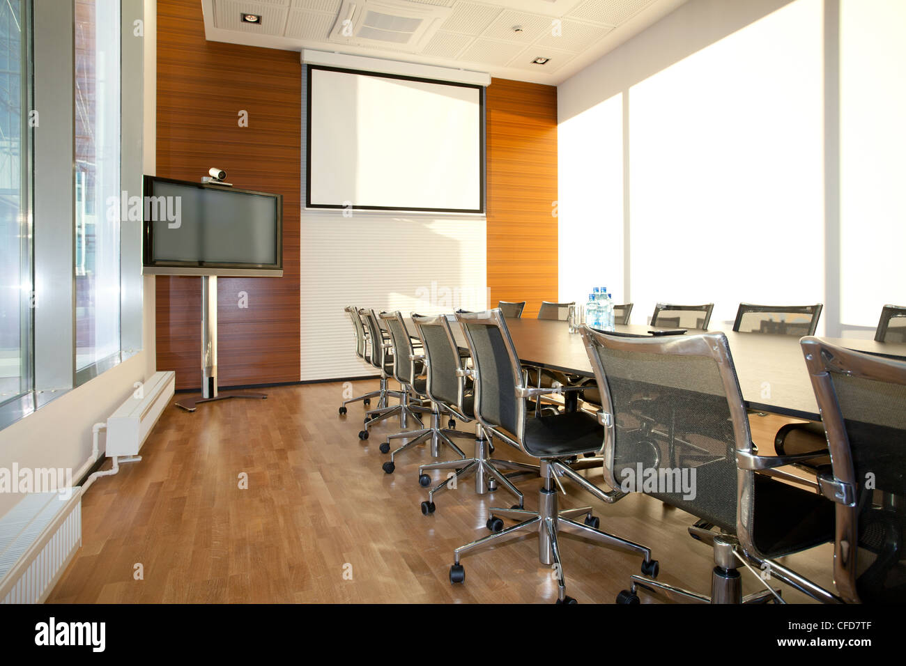 Leere Tagungsraum mit Bildschirm an der Wand, Schreibtisch und Stühle in Roh Stockfoto