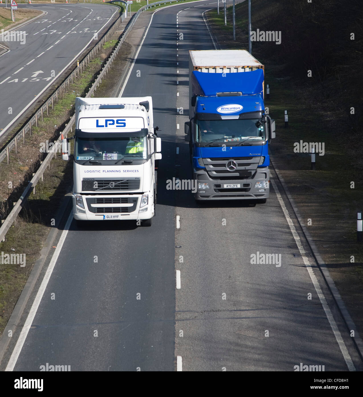 Zwei LKW Lastwagen ein übermäßig unter anderen auf zweispurigen Stockfoto