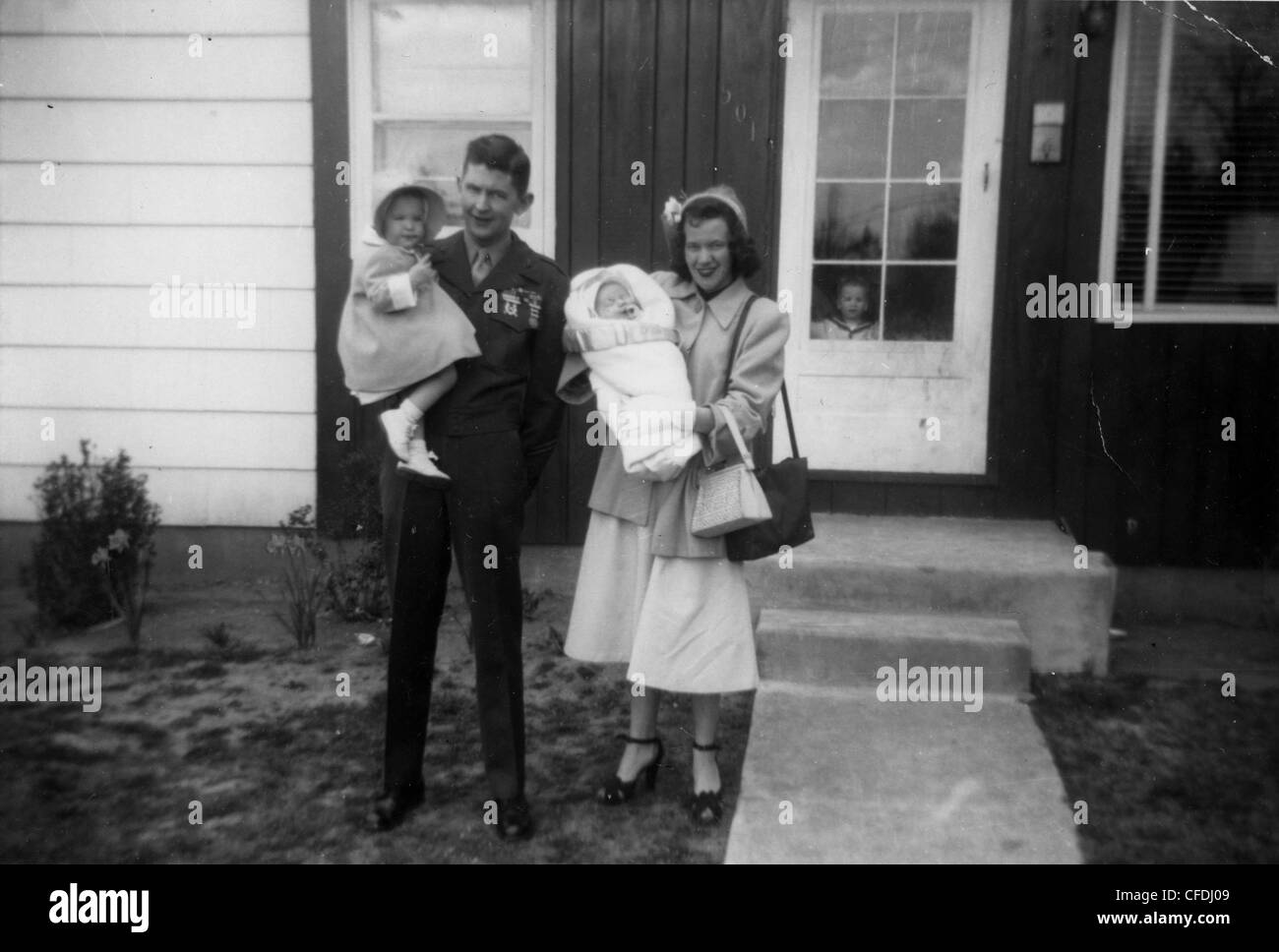 Marine stehen auf Veranda mit Frau und Kindern während WWII militärische Familie 1940er Jahre babyboomers Stockfoto