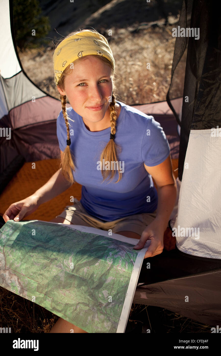 Frau sitzt in ihrem Zelt und eine Landkarte. Stockfoto