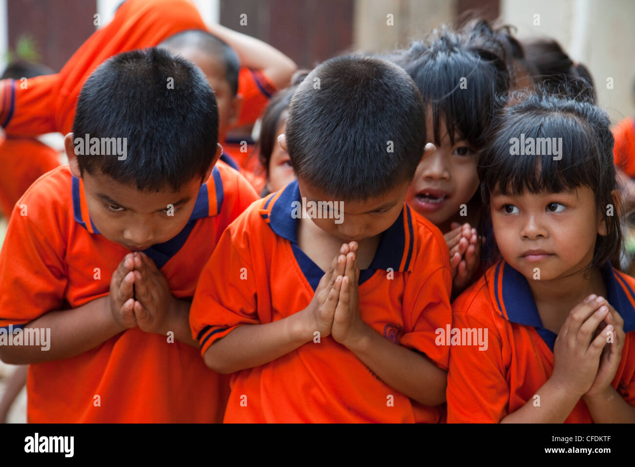 Schülerinnen und Schüler in Uniform begrüßen die Besucher mit Wai Gruß, in der Nähe von Kanchanaburi, Thailand Stockfoto