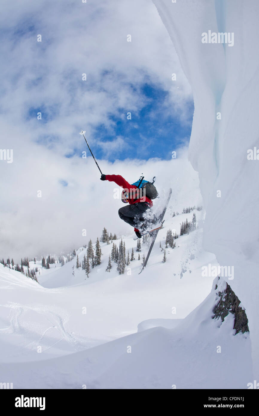 Ein männlicher Skifahrer fängt etwas Luft in frischen Pulverschnee während Skitouren in Sol Mountain Lodge, Monashee, British Columbia, Kanada Stockfoto