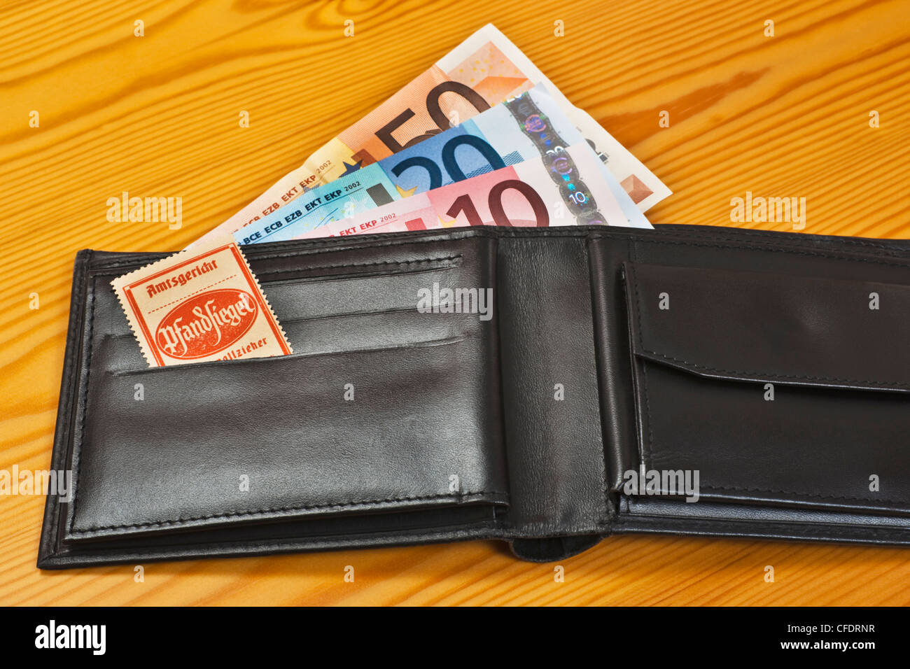 Eine offene Tasche mit Euro-Banknoten, im Inneren befindet sich ein Gerichtsvollzieher Siegel zur Pfändung der Ware. Stockfoto