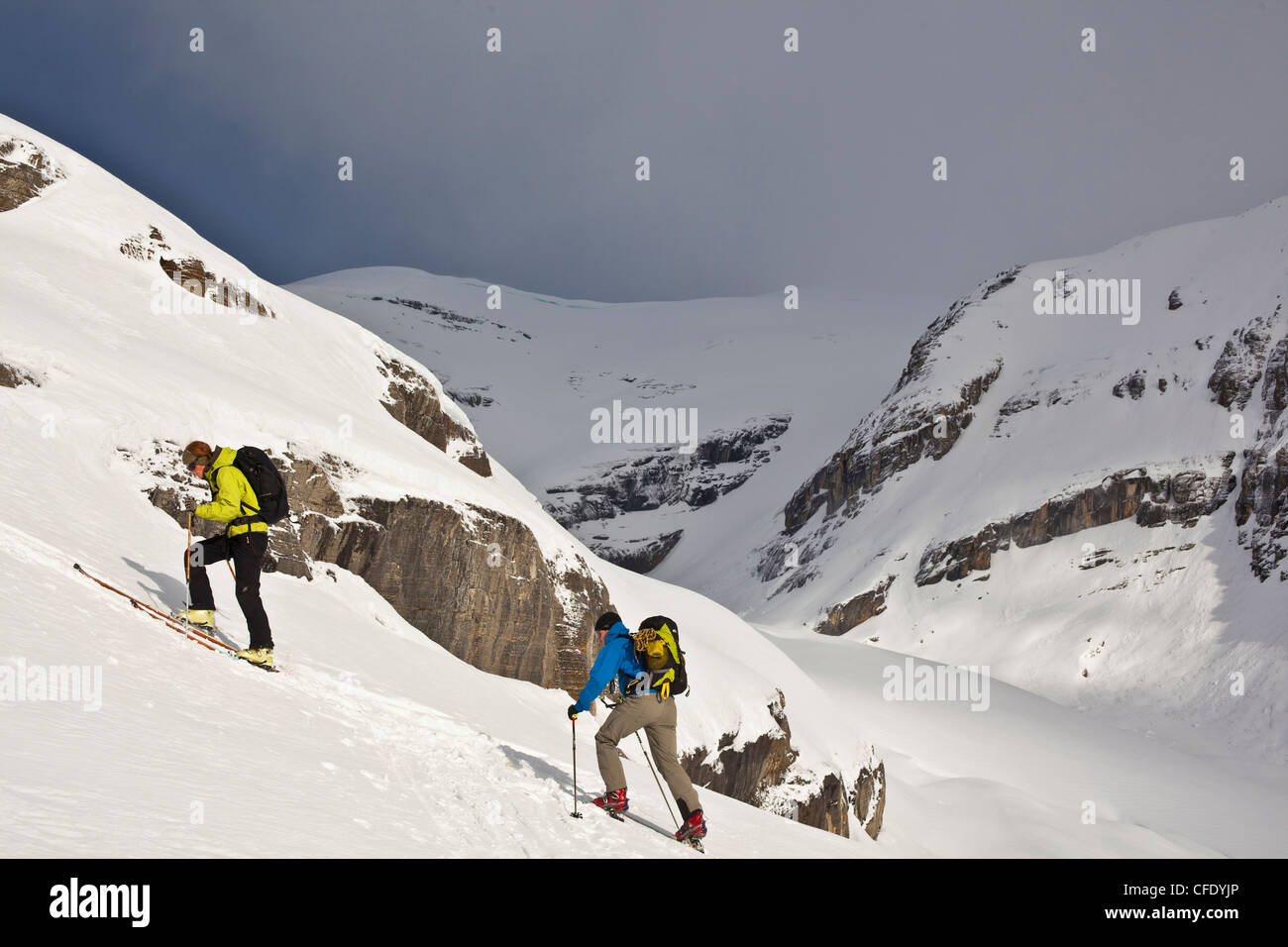 Zwei Backcountry Skifahrer Häutung einen steilen Hang hinauf. Eisfall Lodge, British Columbia, Kanada Stockfoto