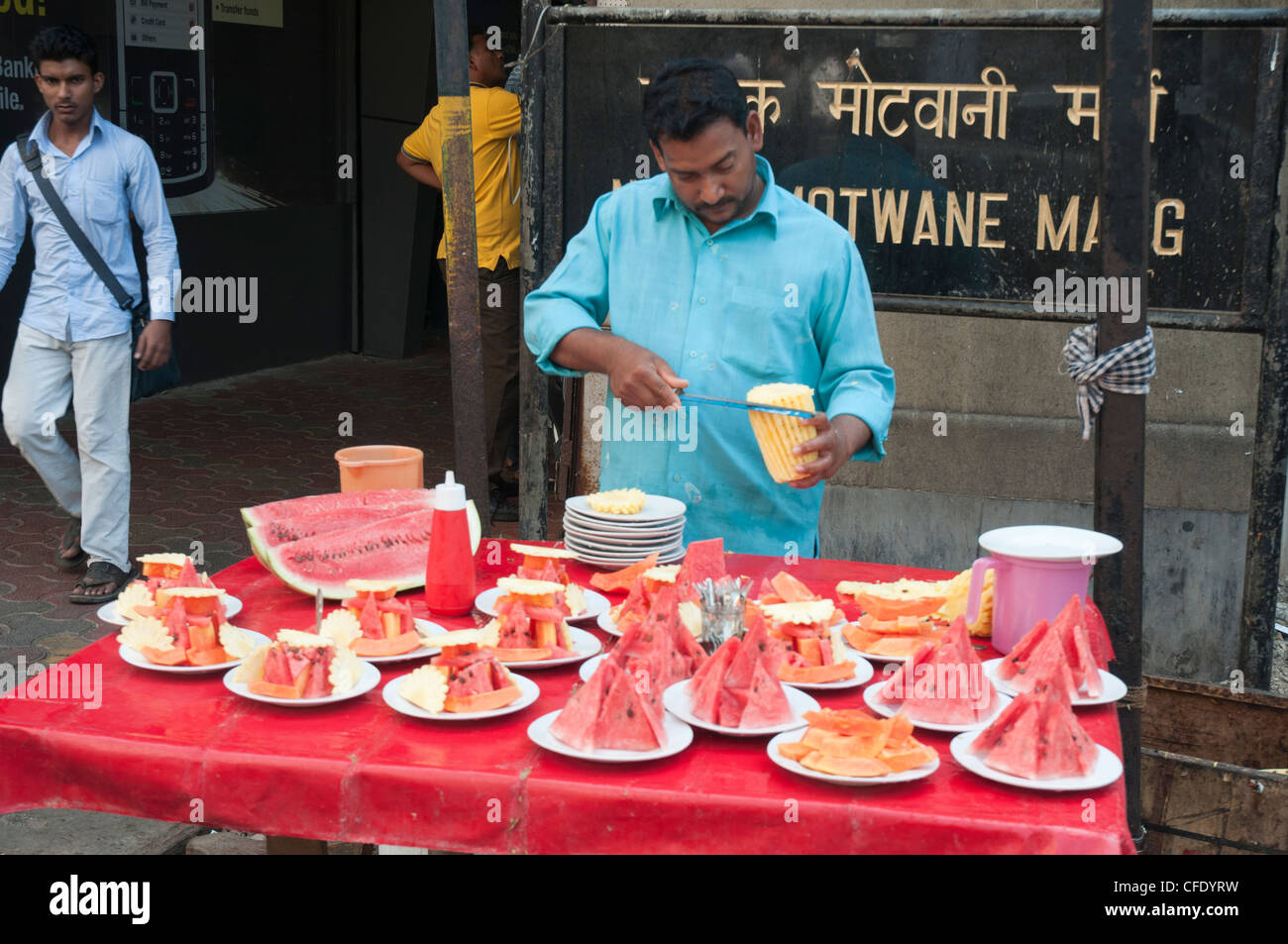 Mann bereitet Teller mit frischem Obst Snacks zum Verkauf in der Innenstadt von Fort Bezirk von Mumbai (Bombay), Indien Stockfoto