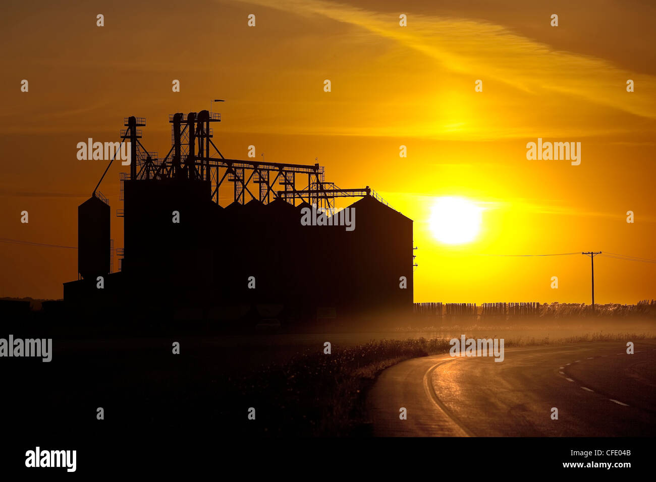 Im Landesinneren Grain Terminal und Trans Canada Highway bei Sonnenuntergang, Saskatchewan, Canada. Stockfoto