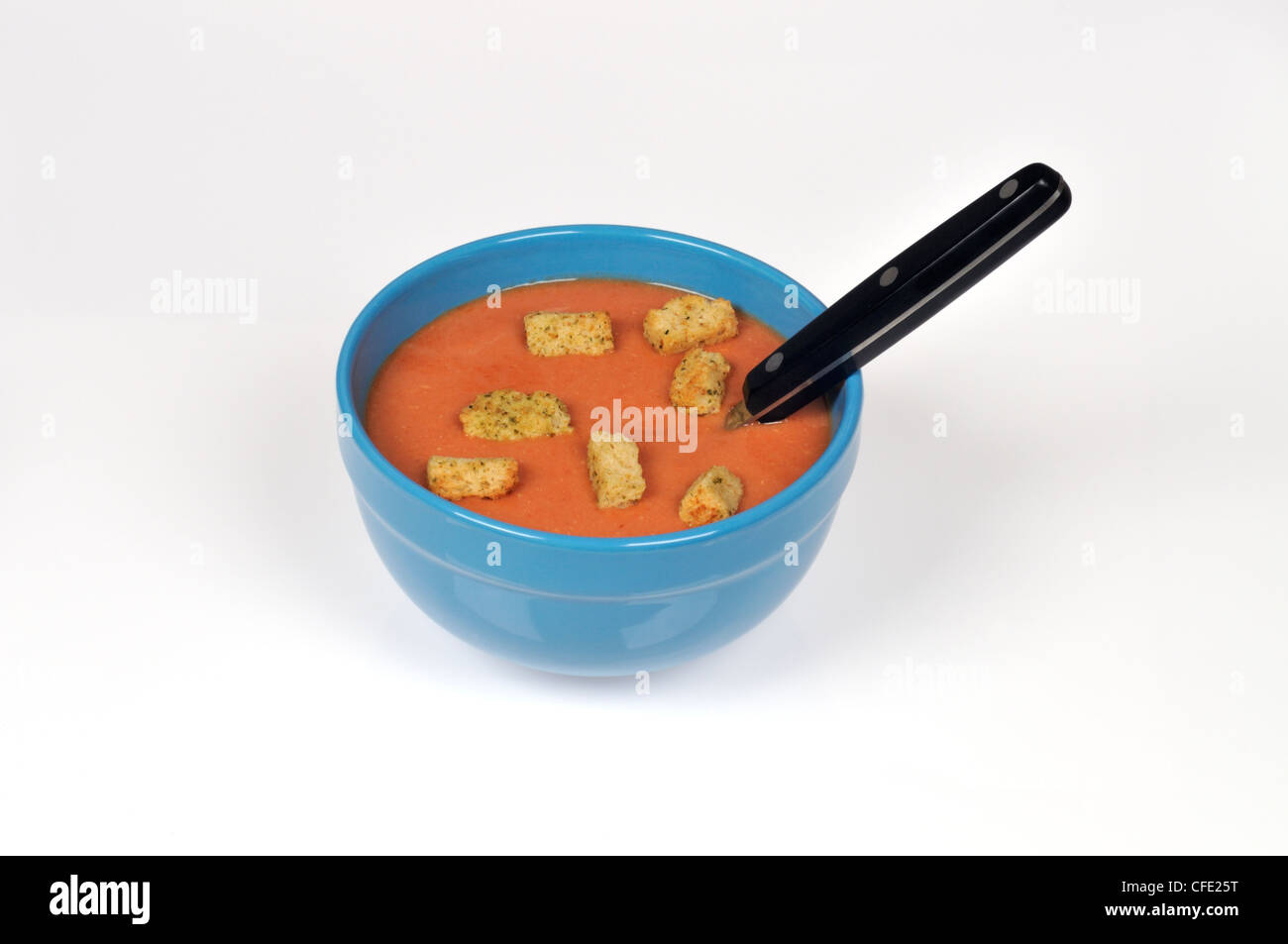 Eine Schüssel Tomatensuppe mit Croutons und einem Löffel auf weißem Hintergrund ausschneiden. Stockfoto