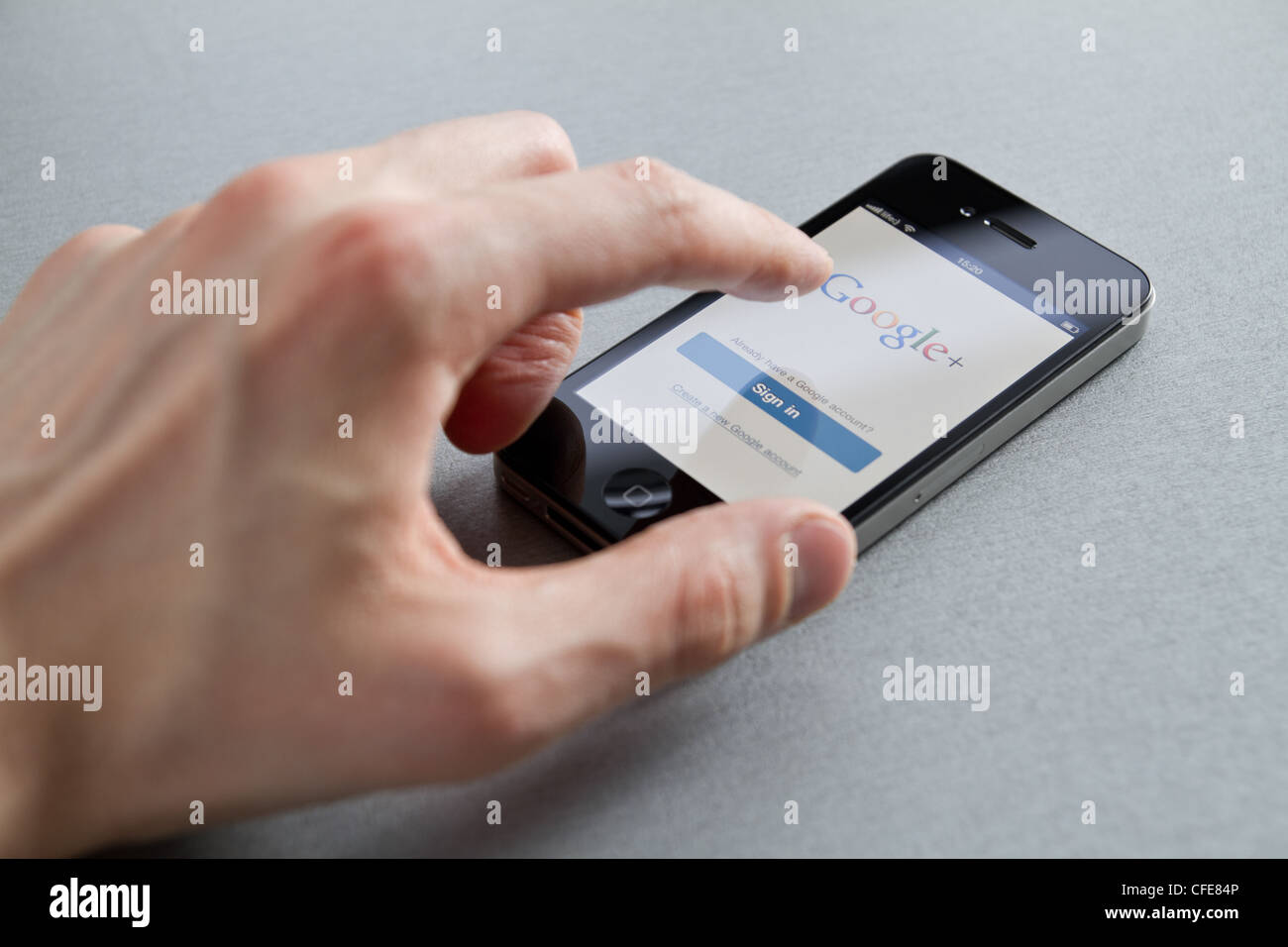 Hand des Mannes Apple iPhone mit Google + Seite auf dem Bildschirm zu berühren. Google + ist ein soziales Netzwerk von Google inc erstellt. Stockfoto