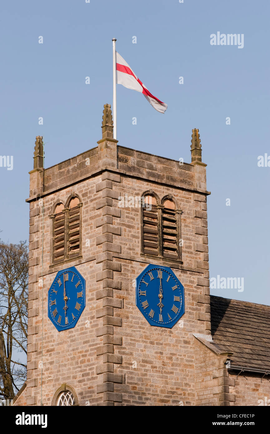 Flagge hoch auf Kirchturm & Zeit malerische St. Peter, am 2 Uhren liest 18.00 Uhr - Sonniger Frühlingsabend, Addingham Dorf, Yorkshire, England. Stockfoto