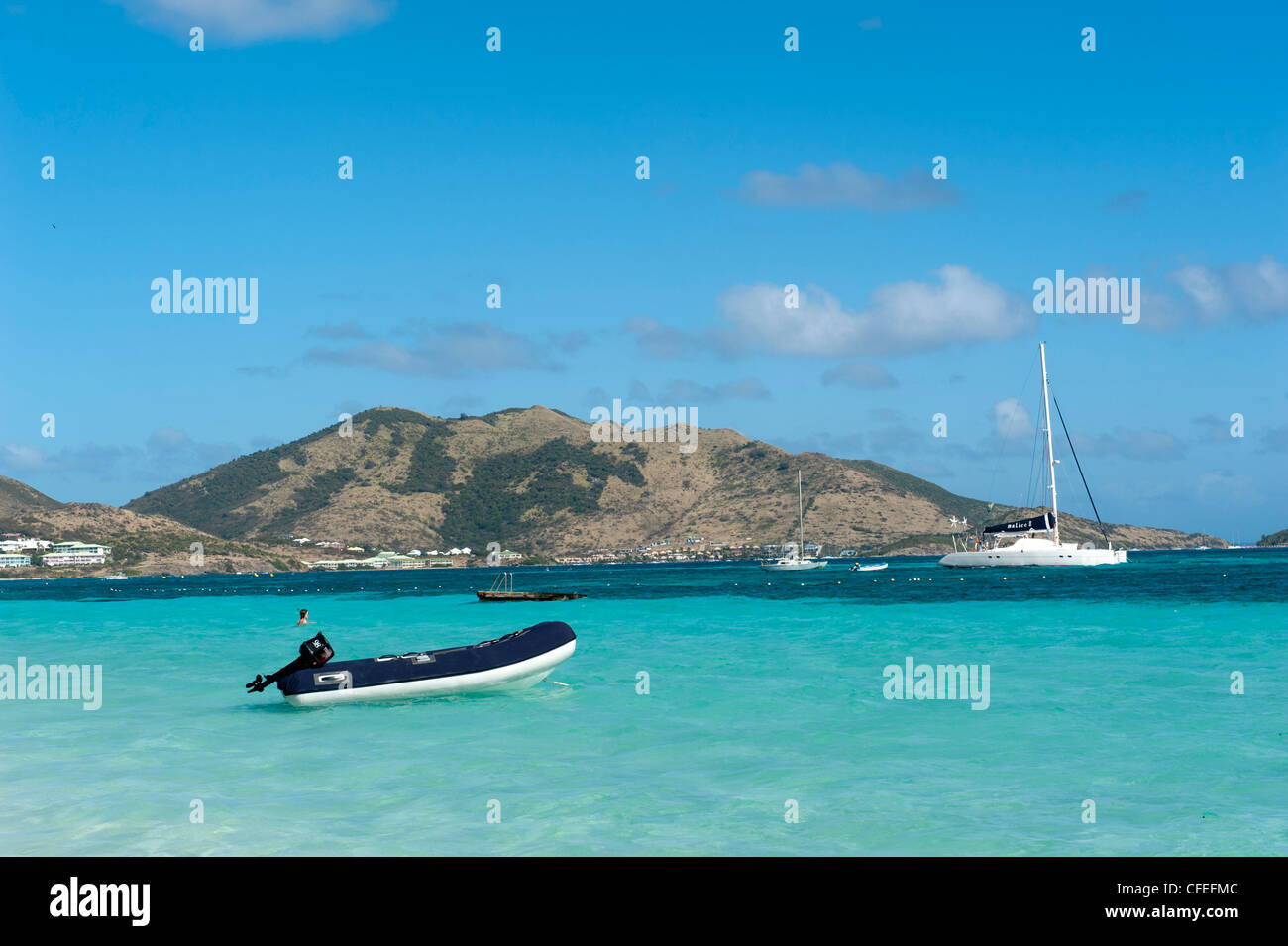 Boote auf dem blauen karibischen Meer, Orient Beach, Saint-Martin mit Bergen am Horizont Stockfoto
