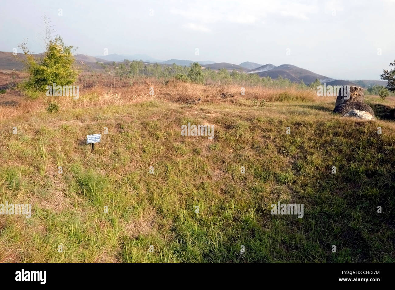 Ein Bombentrichter und Stein Gläser sind auf dem Display auf Ebene der Gläser archäologische Stätte in Phonsavan, Laos. Stockfoto