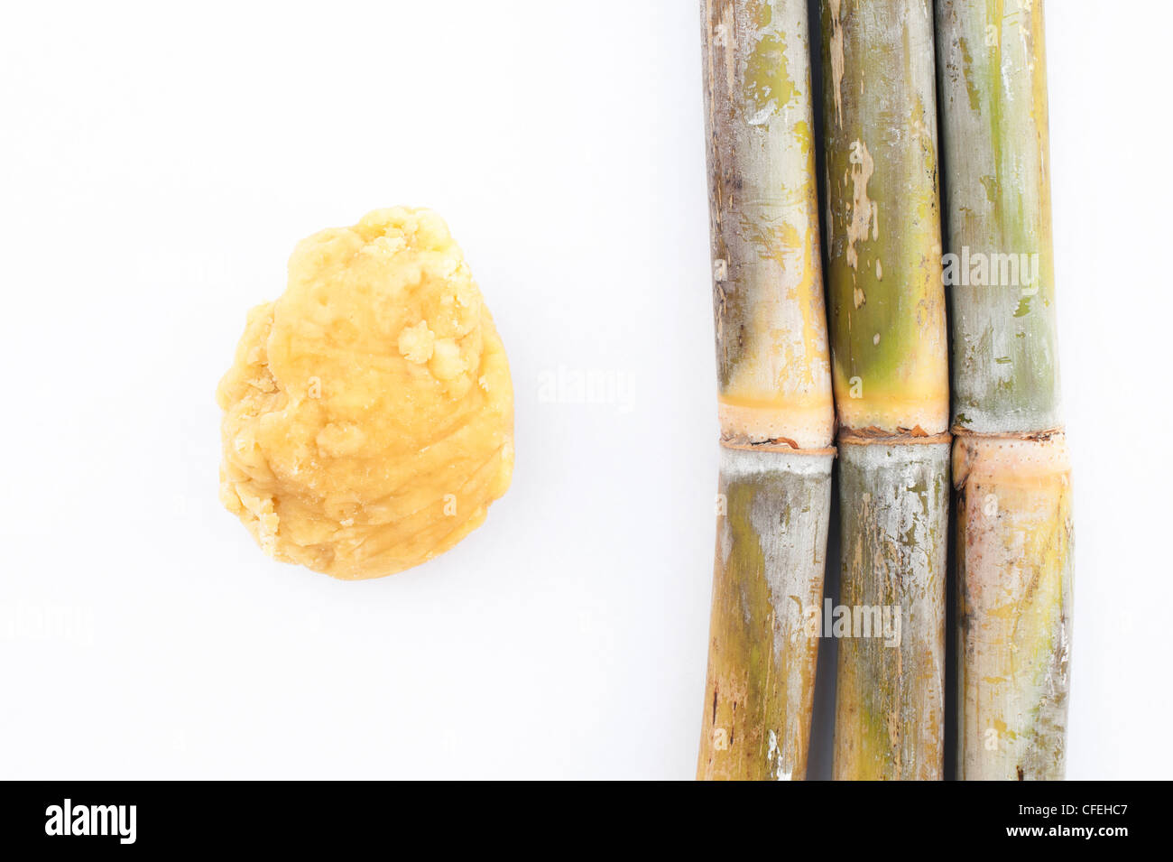 Zuckerrohr mit Jaggery (unraffiniertem Rohrohrzucker) auf weißem Hintergrund Stockfoto