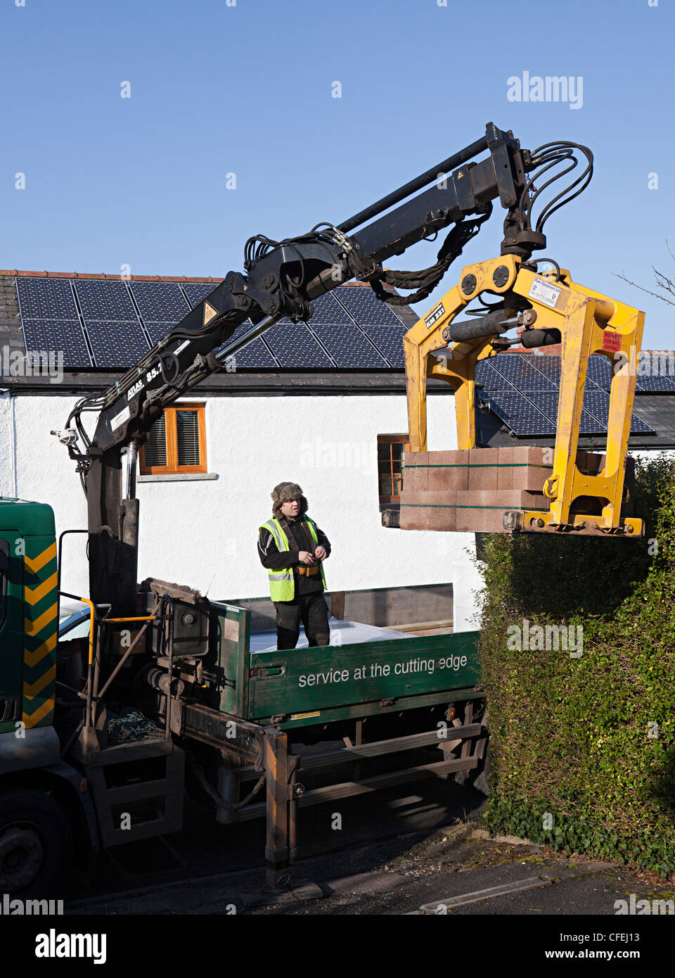 Bau Industrie LKW liefern Betonsteine mit mechanischen Hebezeug, Wales, UK Stockfoto