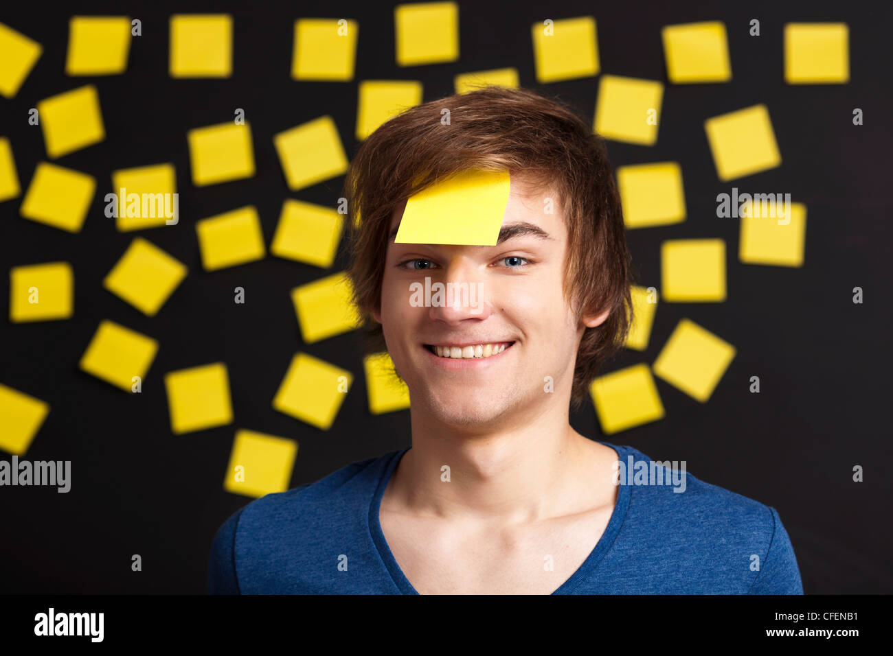 Glückliche Schüler mit einer Erinnerung auf den Kopf, und mit gelblicher Papiernoten im Hintergrund Stockfoto