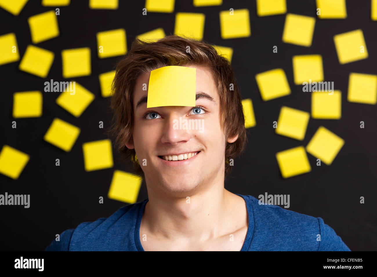 Glückliche Schüler mit einer Erinnerung auf den Kopf, und mit gelblicher Papiernoten im Hintergrund Stockfoto