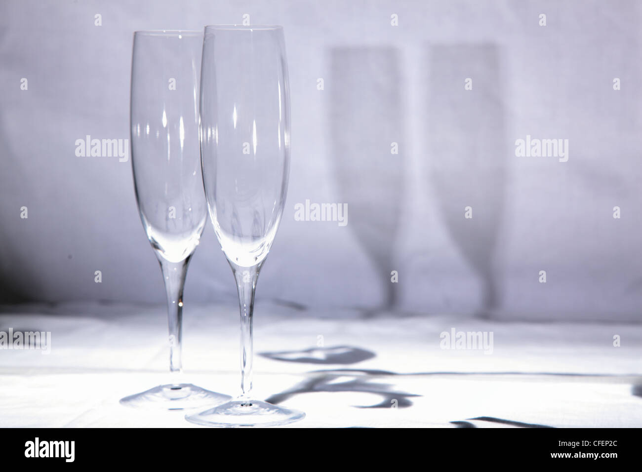 paar Kristall Champagner Flöten Gläser auf weißem Hintergrund mit Schatten Stockfoto