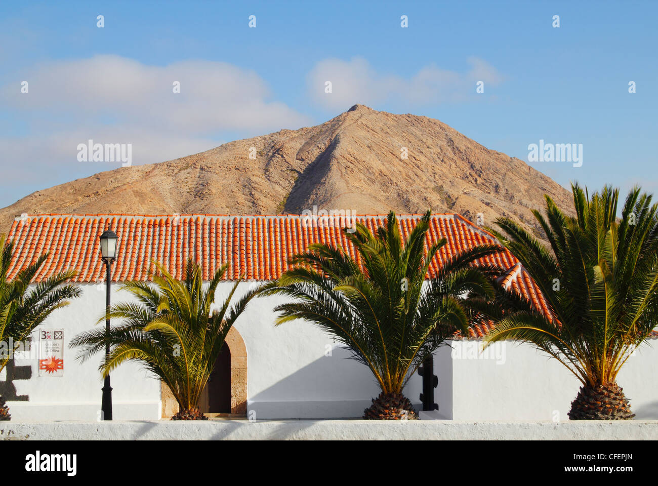 Kirche des Dorfes Virgen De La Caridad InTindaya mit Tindaya Berg im Hintergrund. Fuerteventura, Kanarische Inseln, Spanien Stockfoto