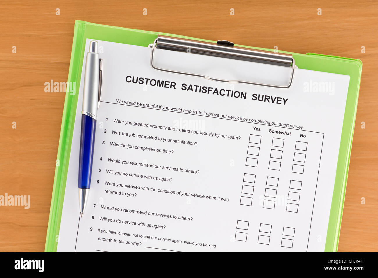 Umfrage zur Kundenzufriedenheit mit Stift auf grüne Zwischenablage Stockfoto