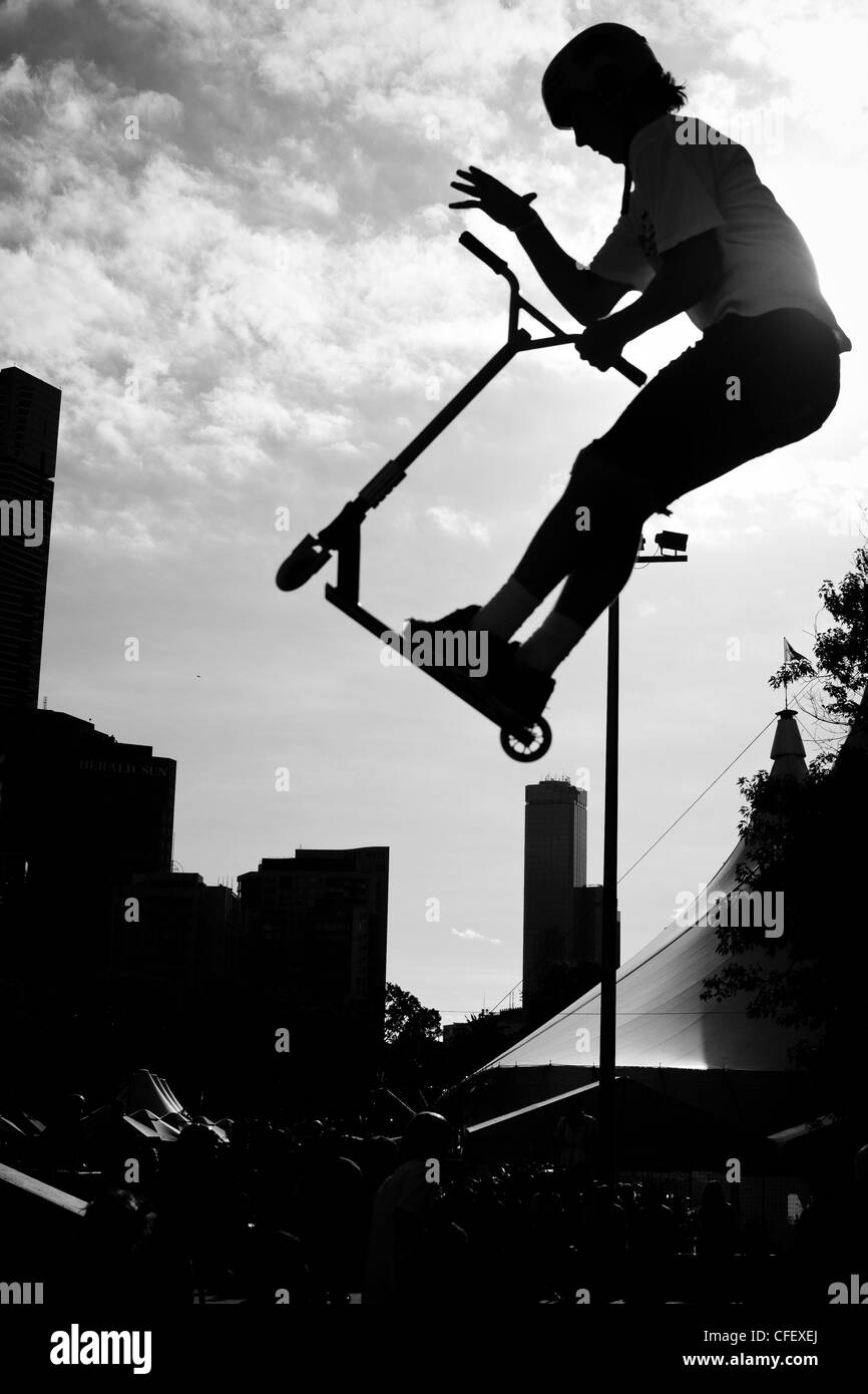 das Foto eines jungen tun einen hohen Sprung auf einem Roller in einem Skatepark am Moomba-Festival 2012 in Melbourne Stockfoto