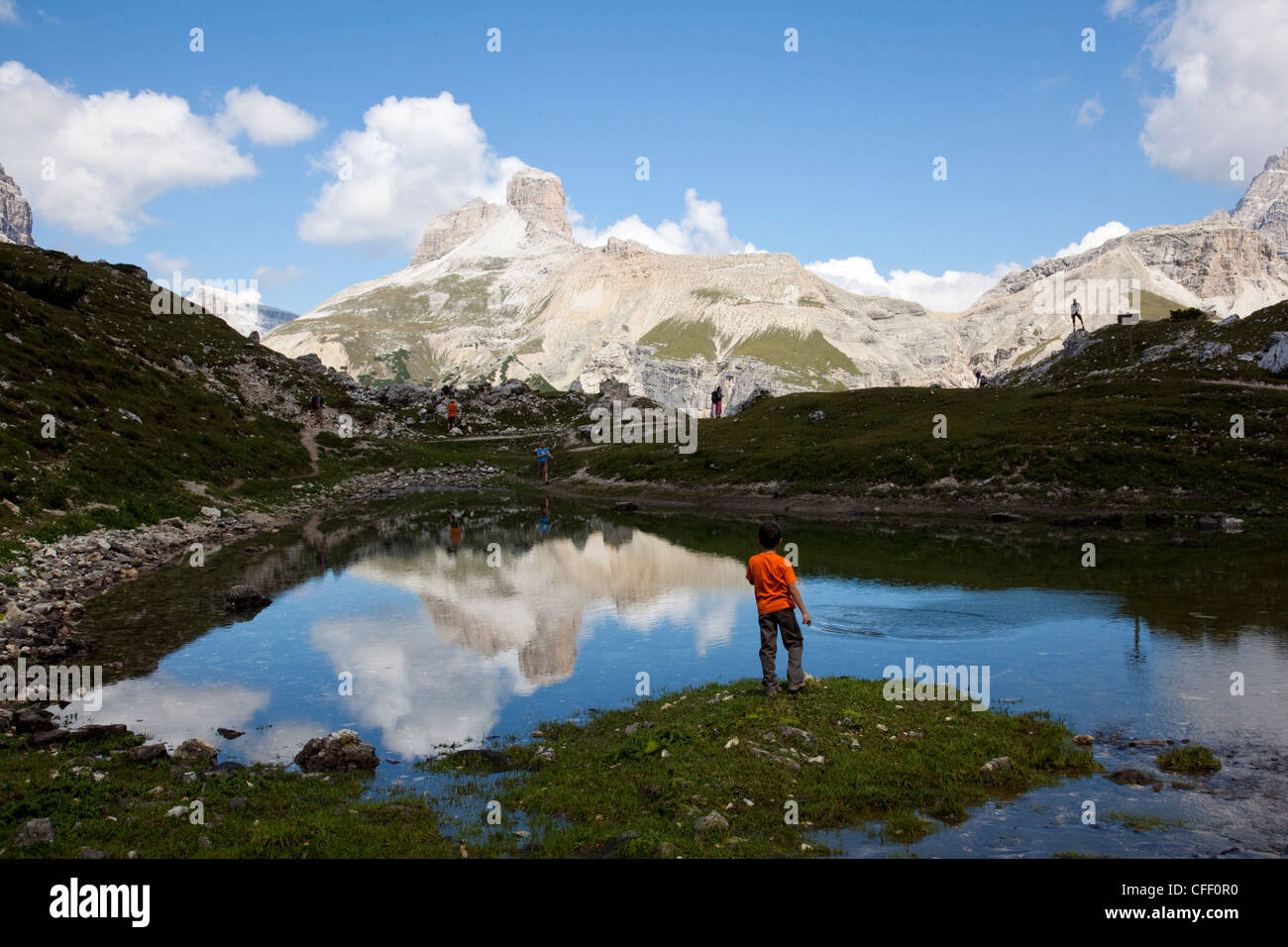 Kind spielt auf einem alpinen Teich, Dolomiten, Ostalpen, Belluno Provinz, Italien, Europa Stockfoto
