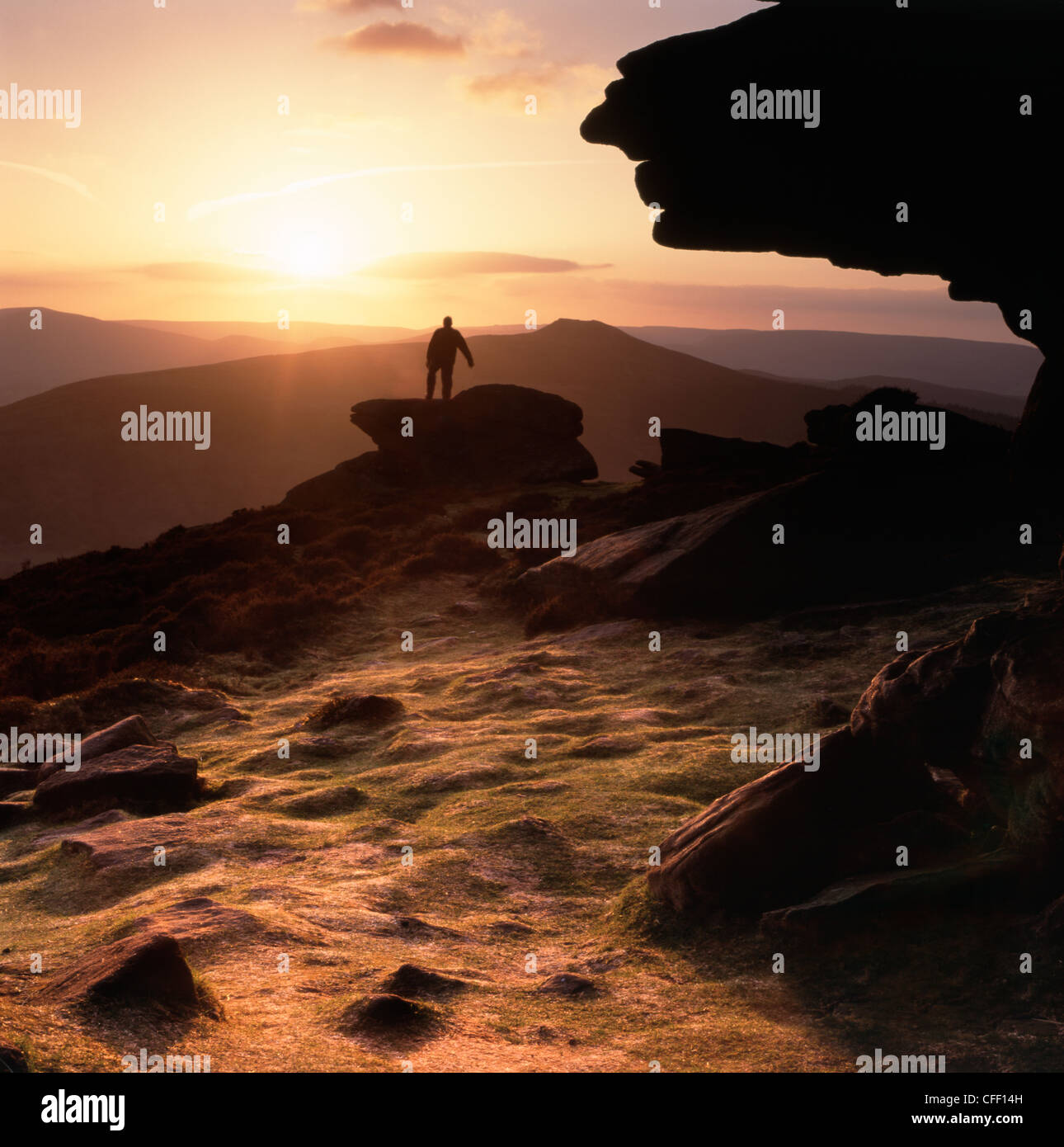 Einsame männliche Walker Stand auf Felsen betrachten den Sonnenuntergang am Rand Bamford in Derbyshire "Great Britain" Stockfoto