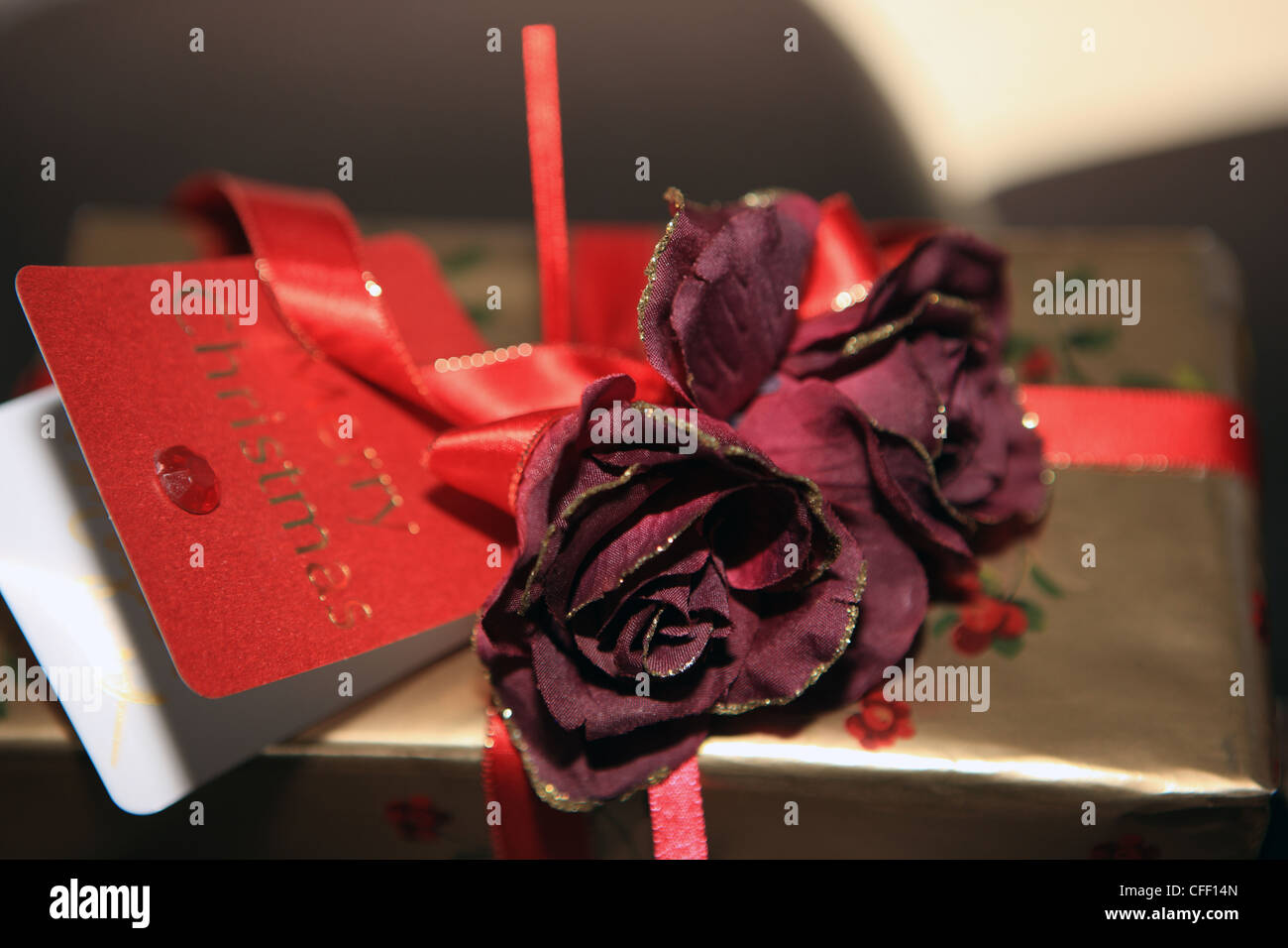 Weihnachtsgeschenk mit Tag, Bändern und Blumen Stockfoto