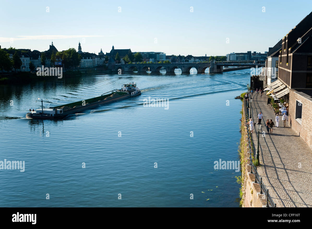 Lastkahn auf der Maas, St.-Servatius-Brücke und Kaffeebars am Maaspuntweg am Flussufer, Maastricht, Limburg, Niederlande Stockfoto