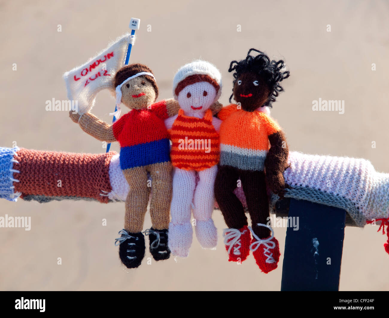 Yarn Bombing schmücken öffentliche Plätze mit gestrickten Objekte hier Olympische Zuschauer auf den Handlauf am Saltburn pier Stockfoto