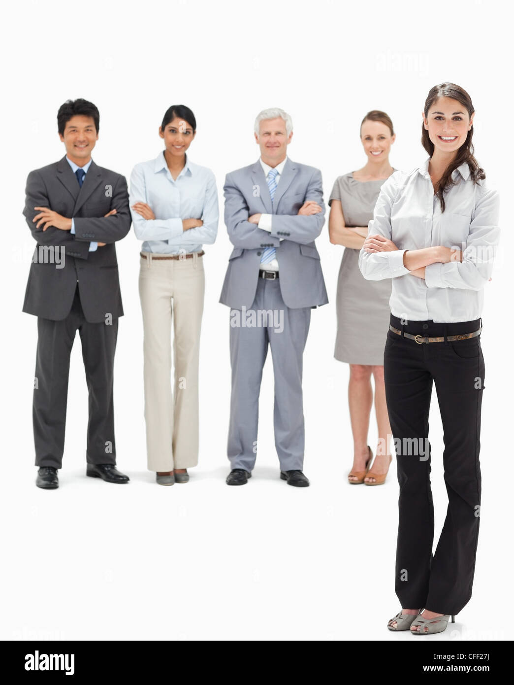 Business-Team mit ihren Armen lächelnd mit einer Frau im Vordergrund gefaltet Stockfoto