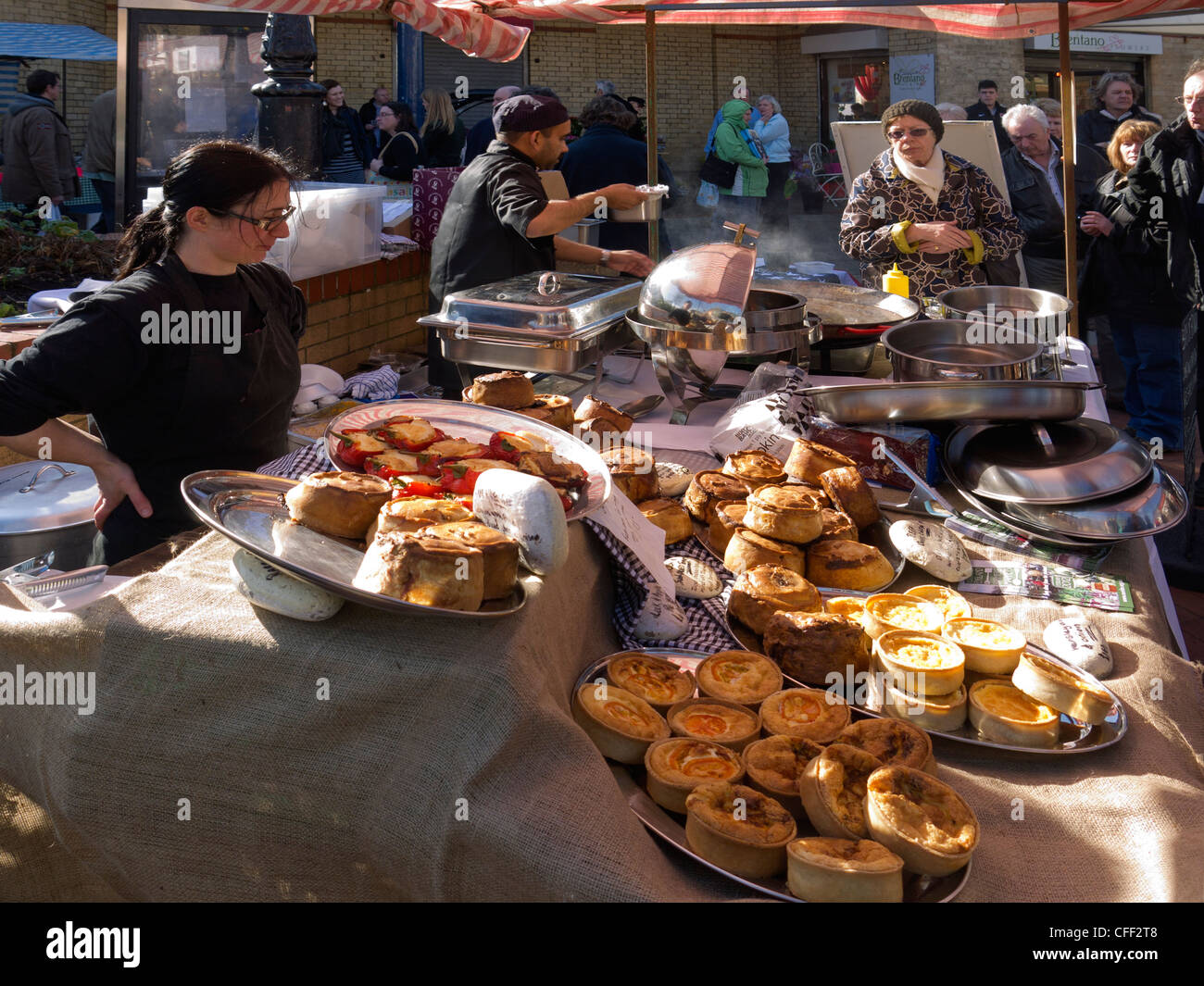 Lady Standinhaber auf einem Bauernmarkt verkaufen Kuchen Quiches gekocht und gefüllte Paprika Stockfoto